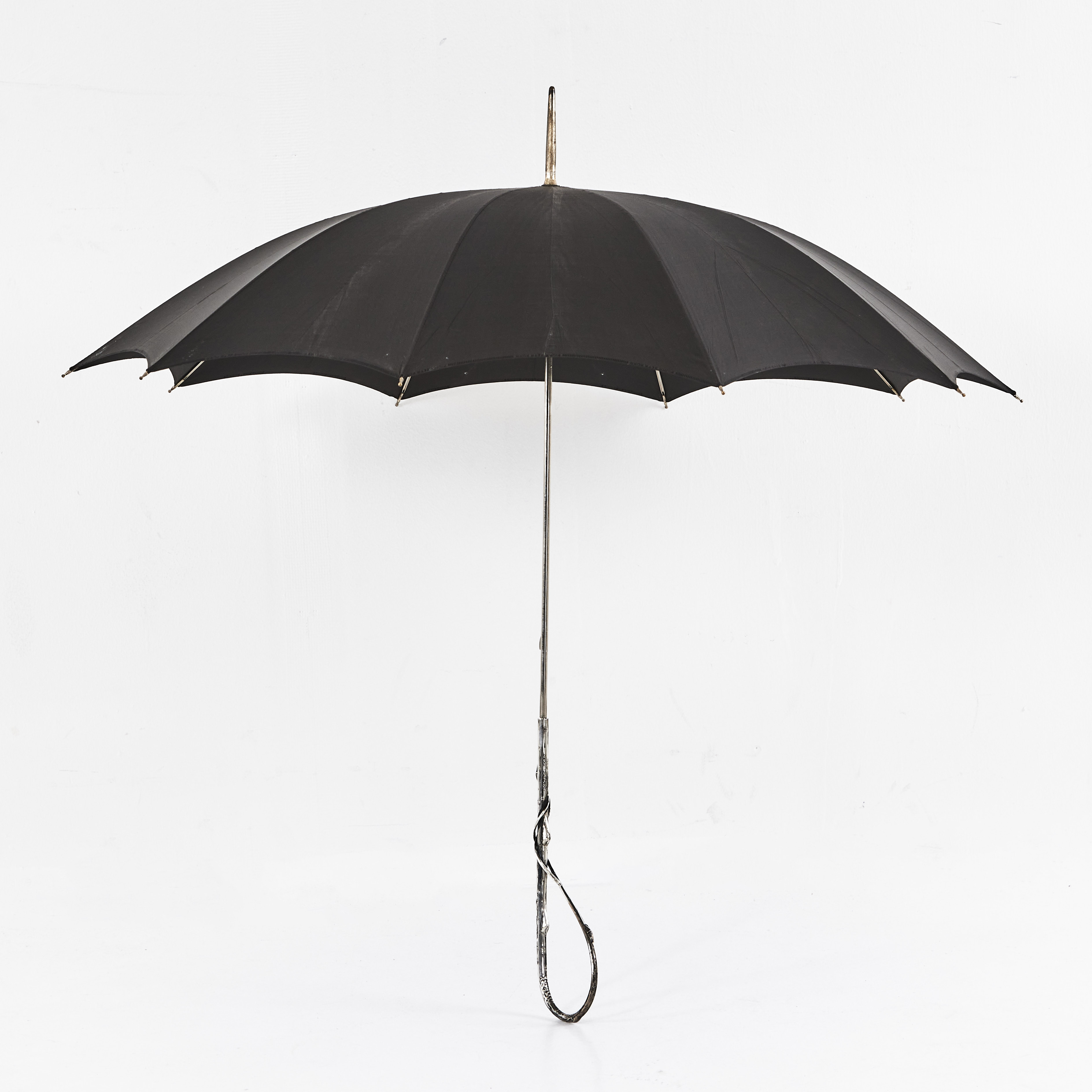PARAPLY, italienskt, klätt i svart siden, handtag i silver (800), med naturalistisk utformning i form av vriden kvist, 1900-talets början.