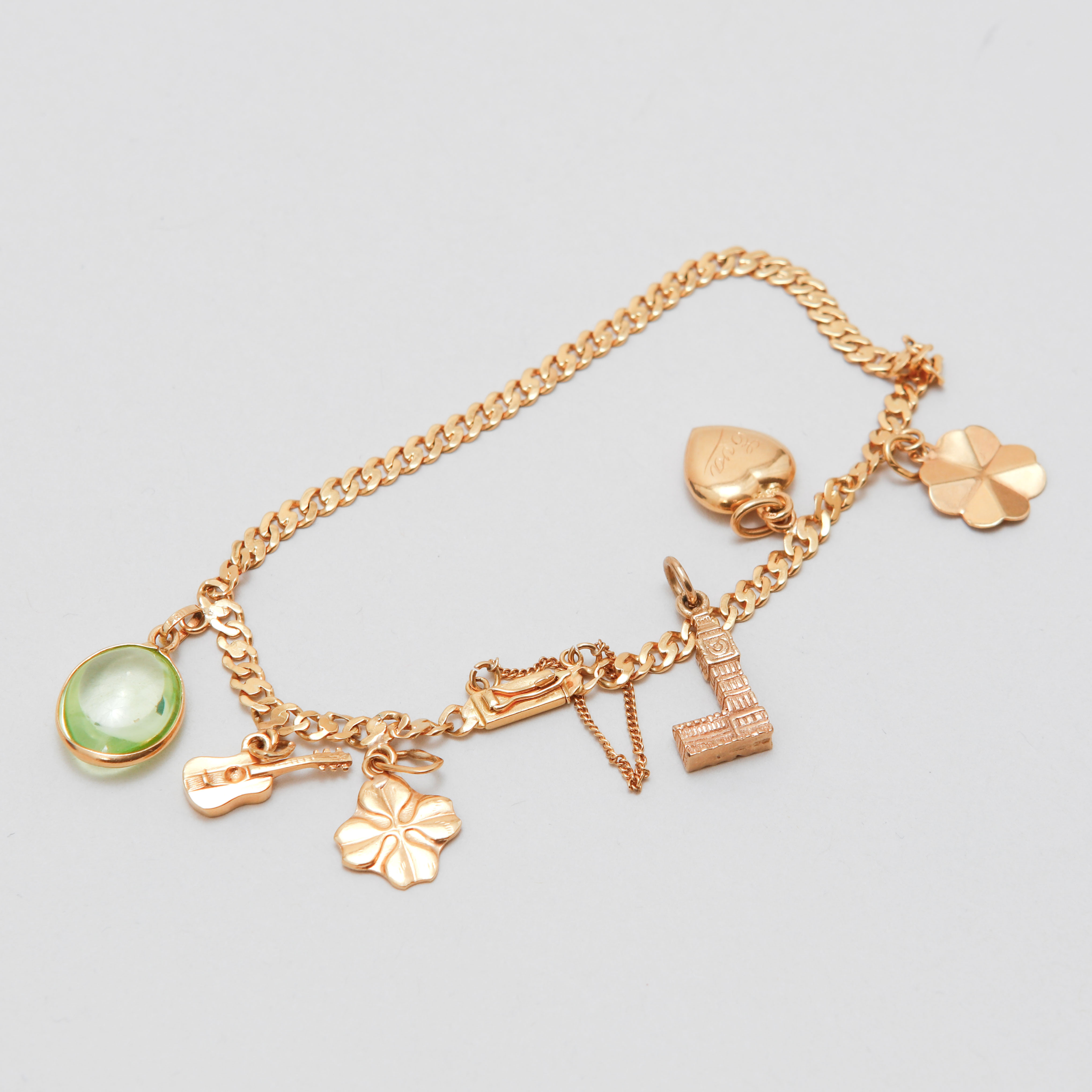 ARMLÄNK med sex berlocker, 18k guld. Vikt ca 10,2 g.