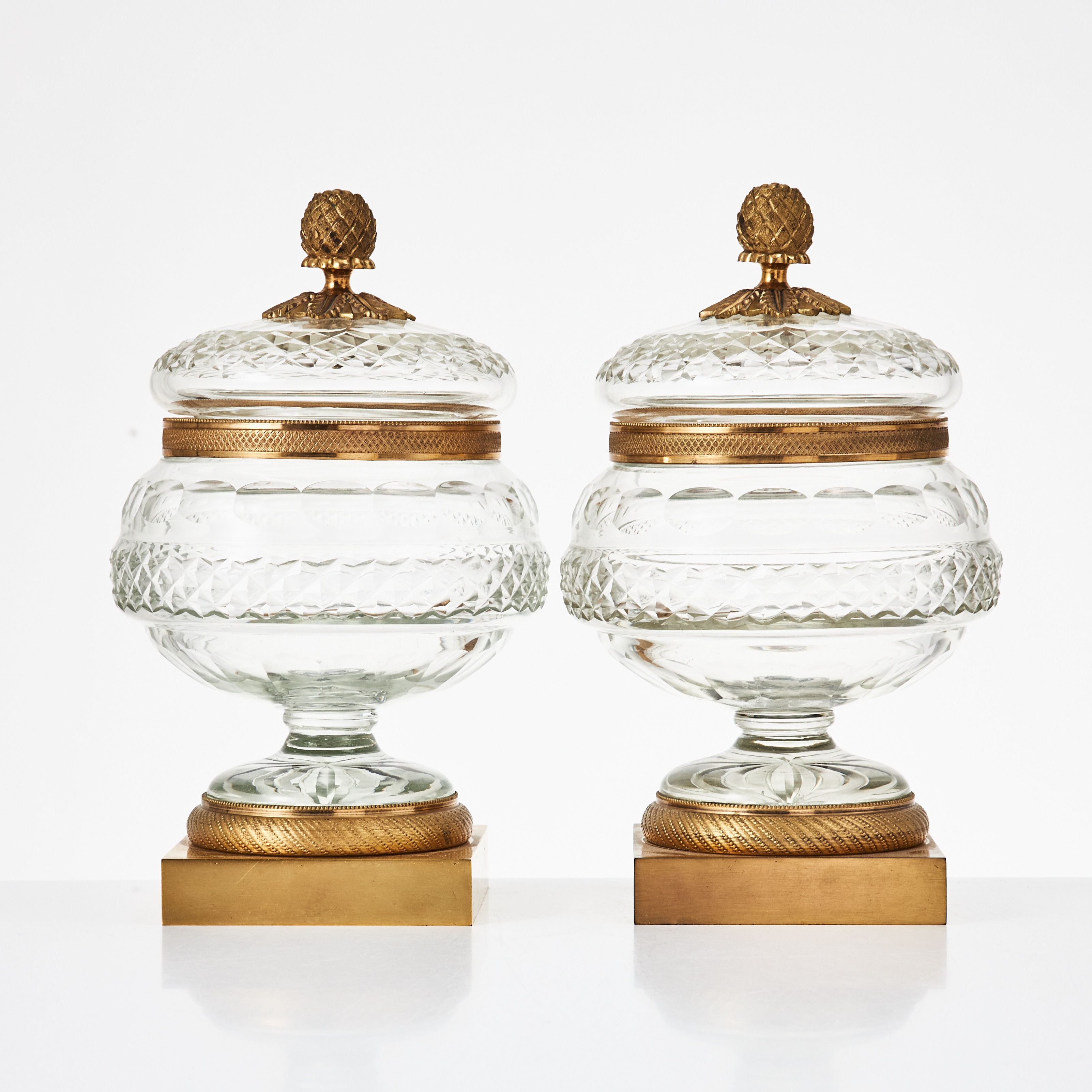 SKÅLAR med lock, 1 par, 1900-tal, empirestil, förgylld brons och slipat glas, lockknopp i form av pinjekotte.