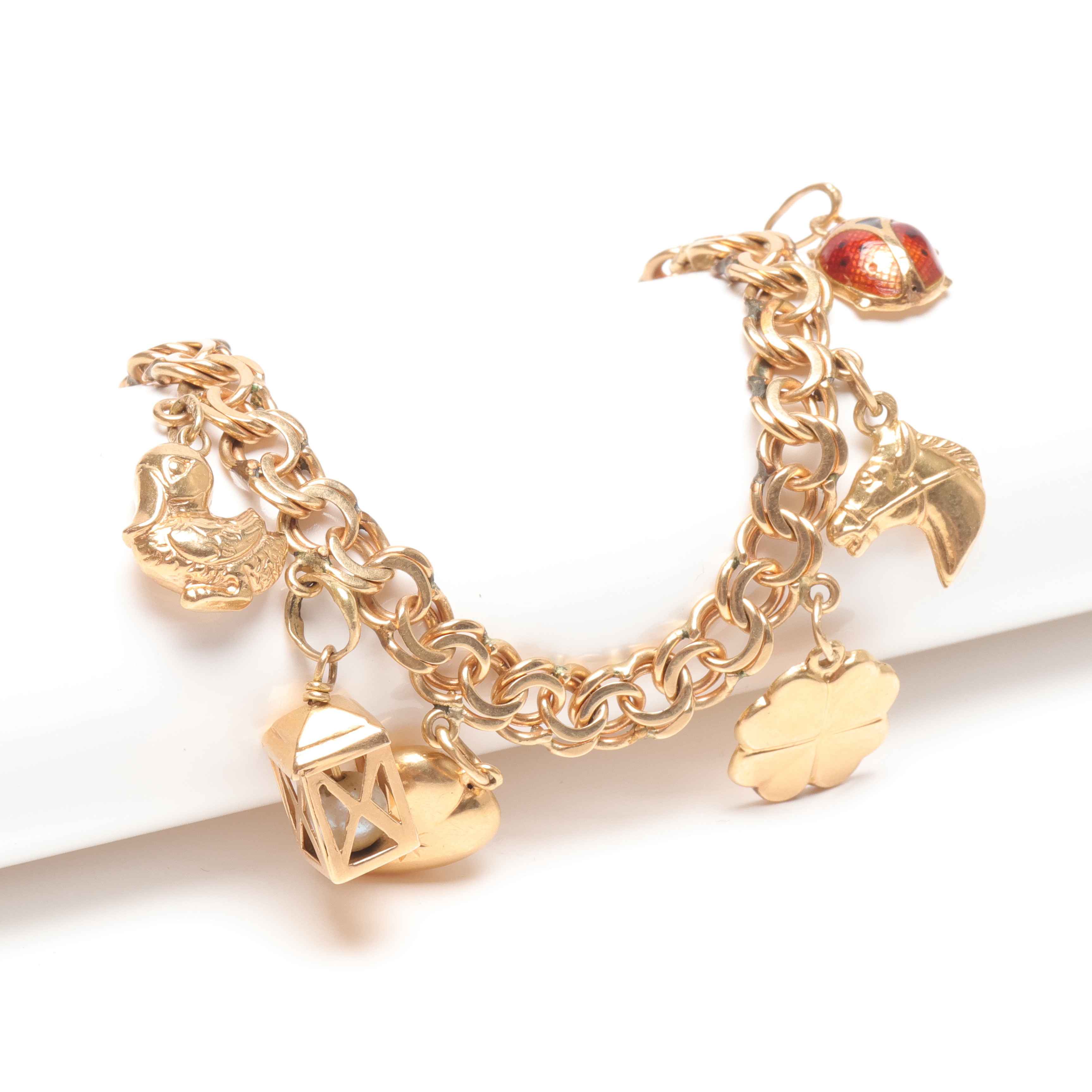 ARMBAND med berlocker, 18k guld, vikt ca 18,7 gram.