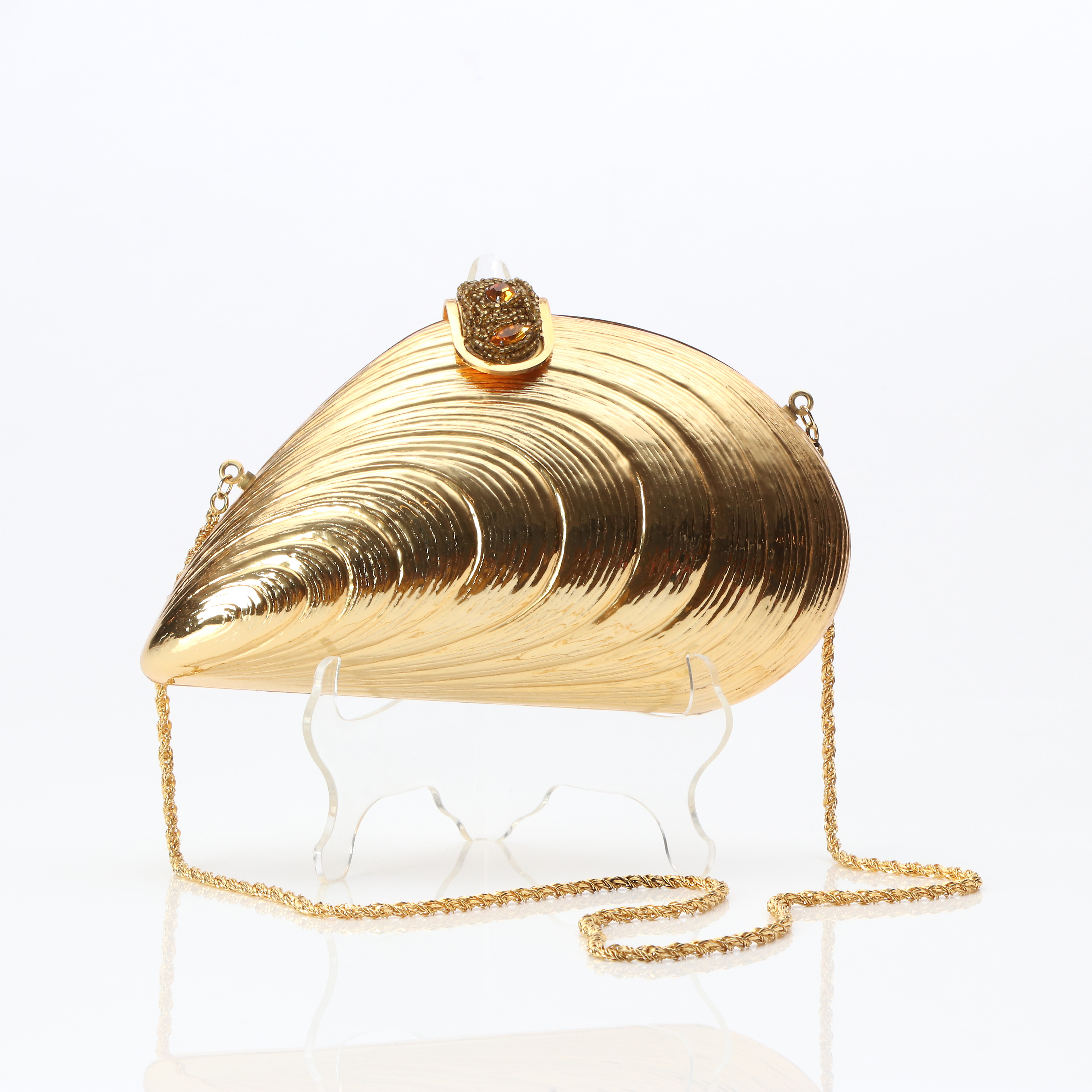 FIOR, AFTONVÄSKA. Förgylld metall med glaspärlor, i form av en mussla.