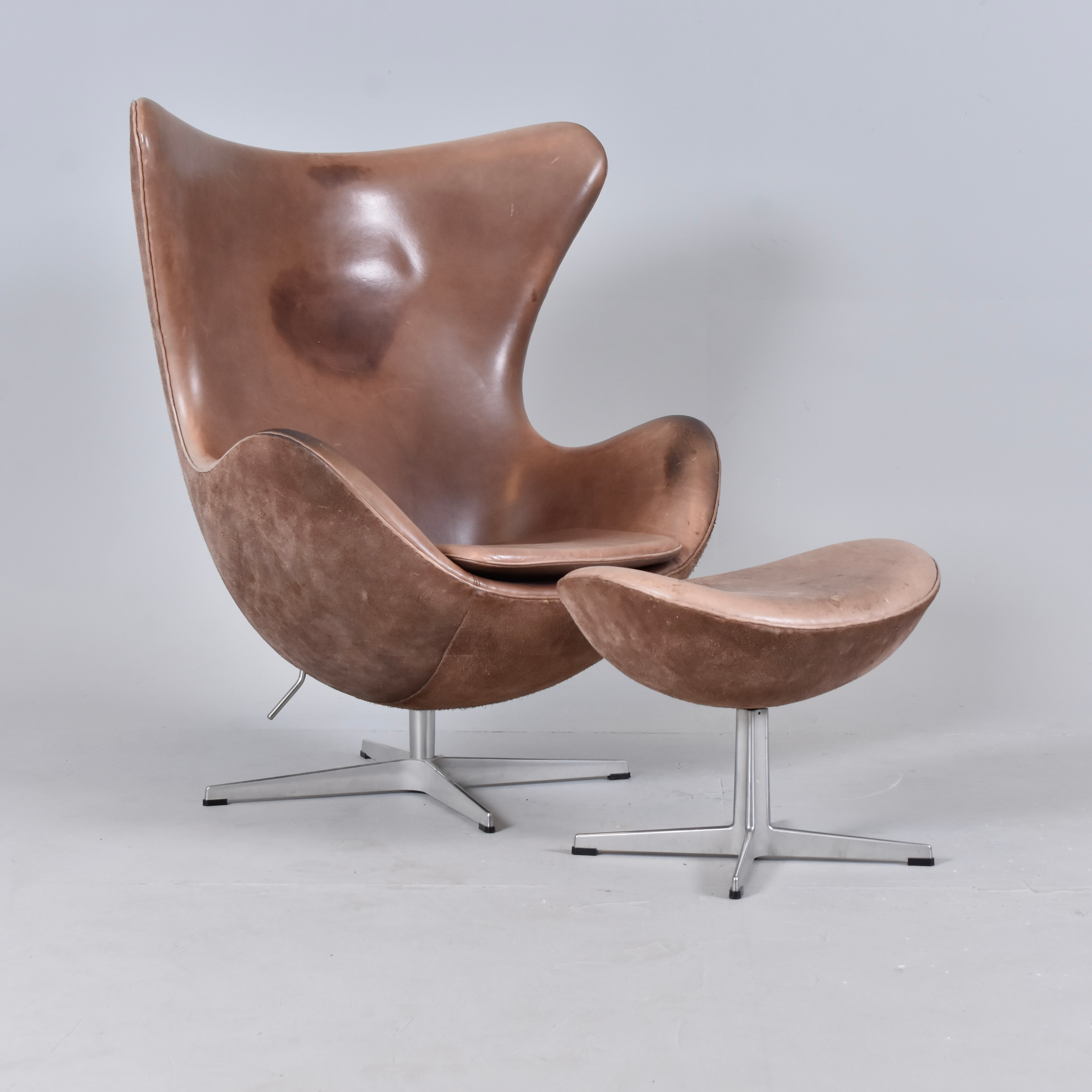 ARNE JACOBSEN. fåtölj med fotpall, brunt läder och mocca på aluminiumfot, "Ägget".