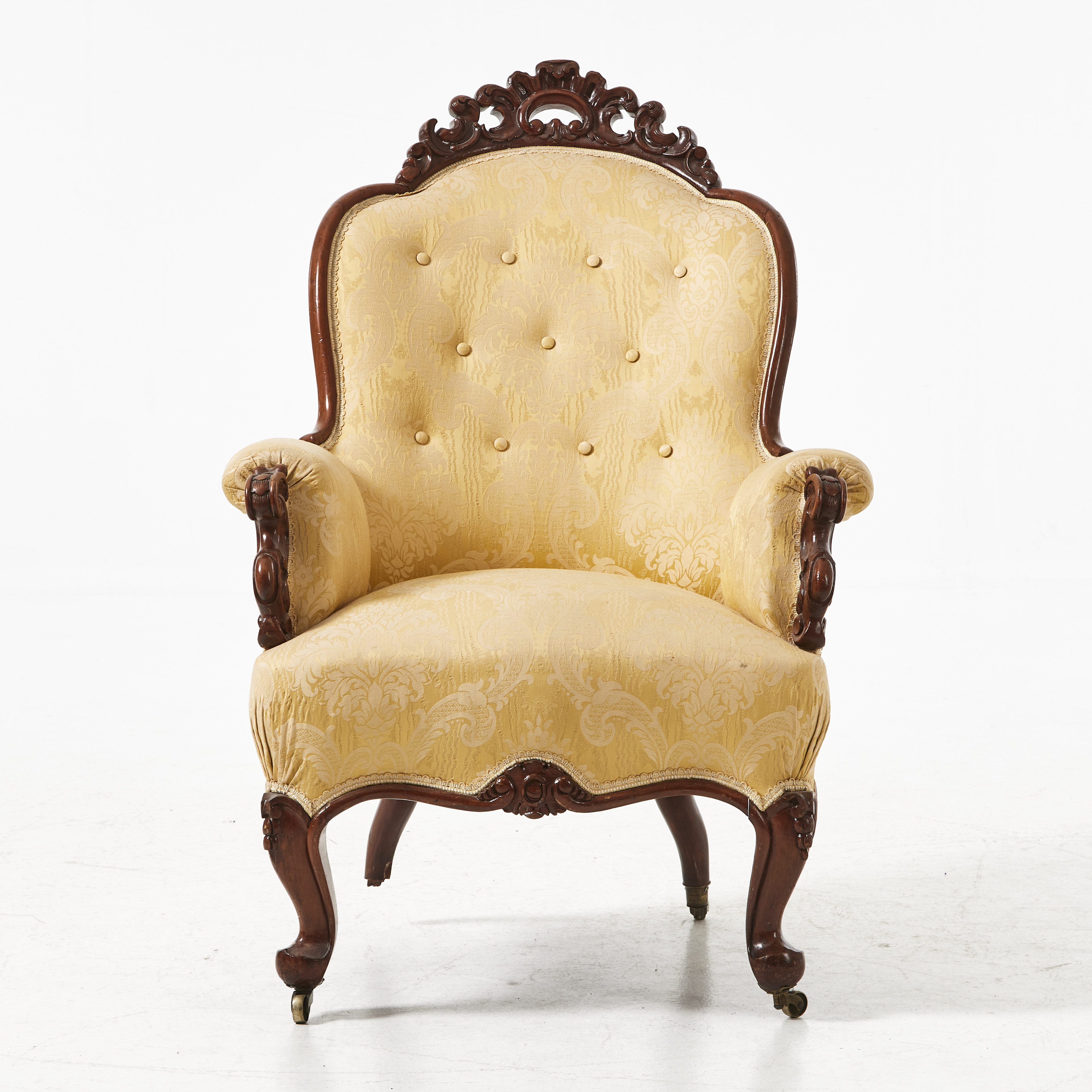 FÅTÖLJ, fanerad i mahogny, 1800-talets andra hälft, nyrokoko, skuren dekor, svängda ben på hjultrissor.