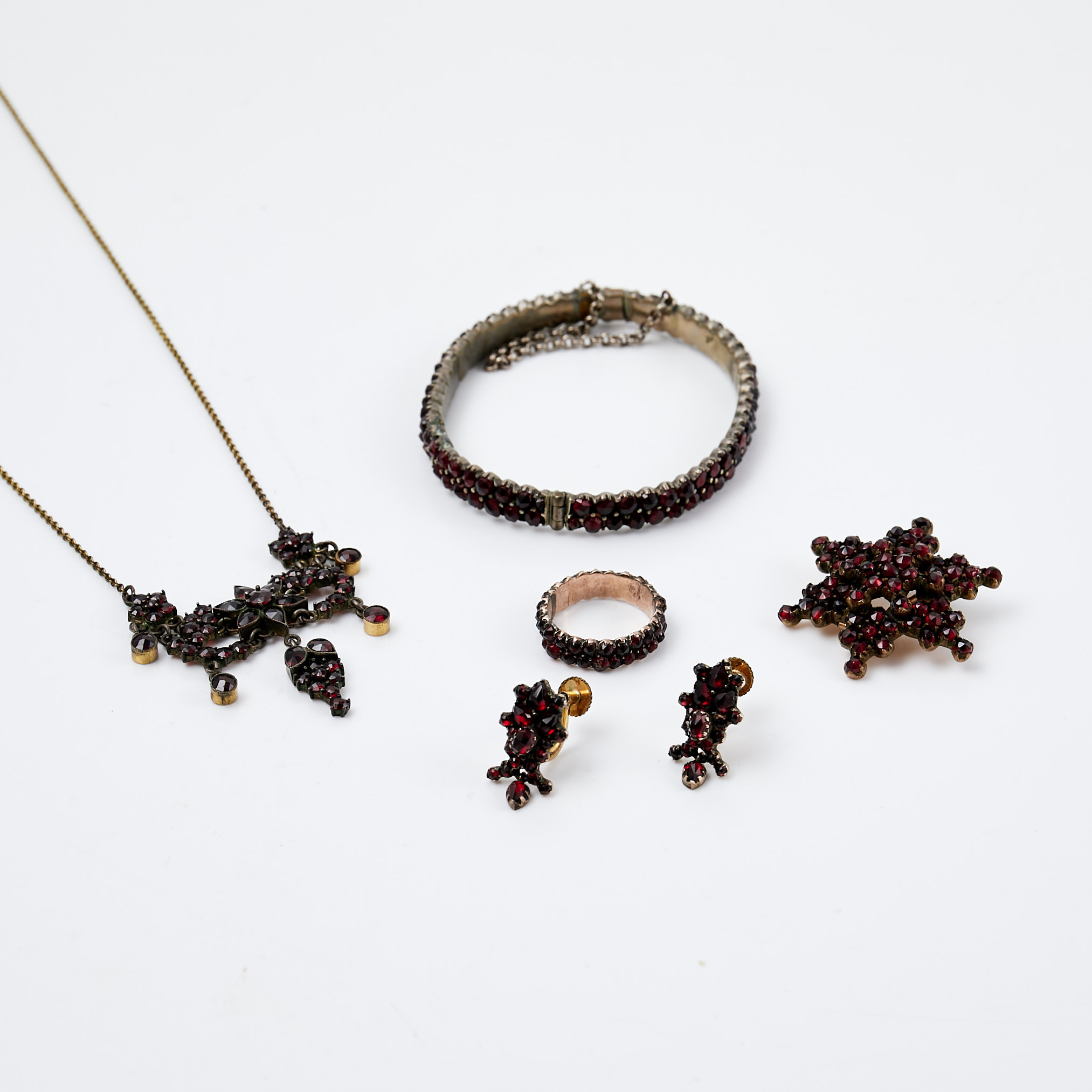HALSBAND, ARMRING, BROSCH, RING, ÖRHÄNGEN, 1 par, metall, delvis förgylld, 1900-talets första hälft, fasettslipade granater.
