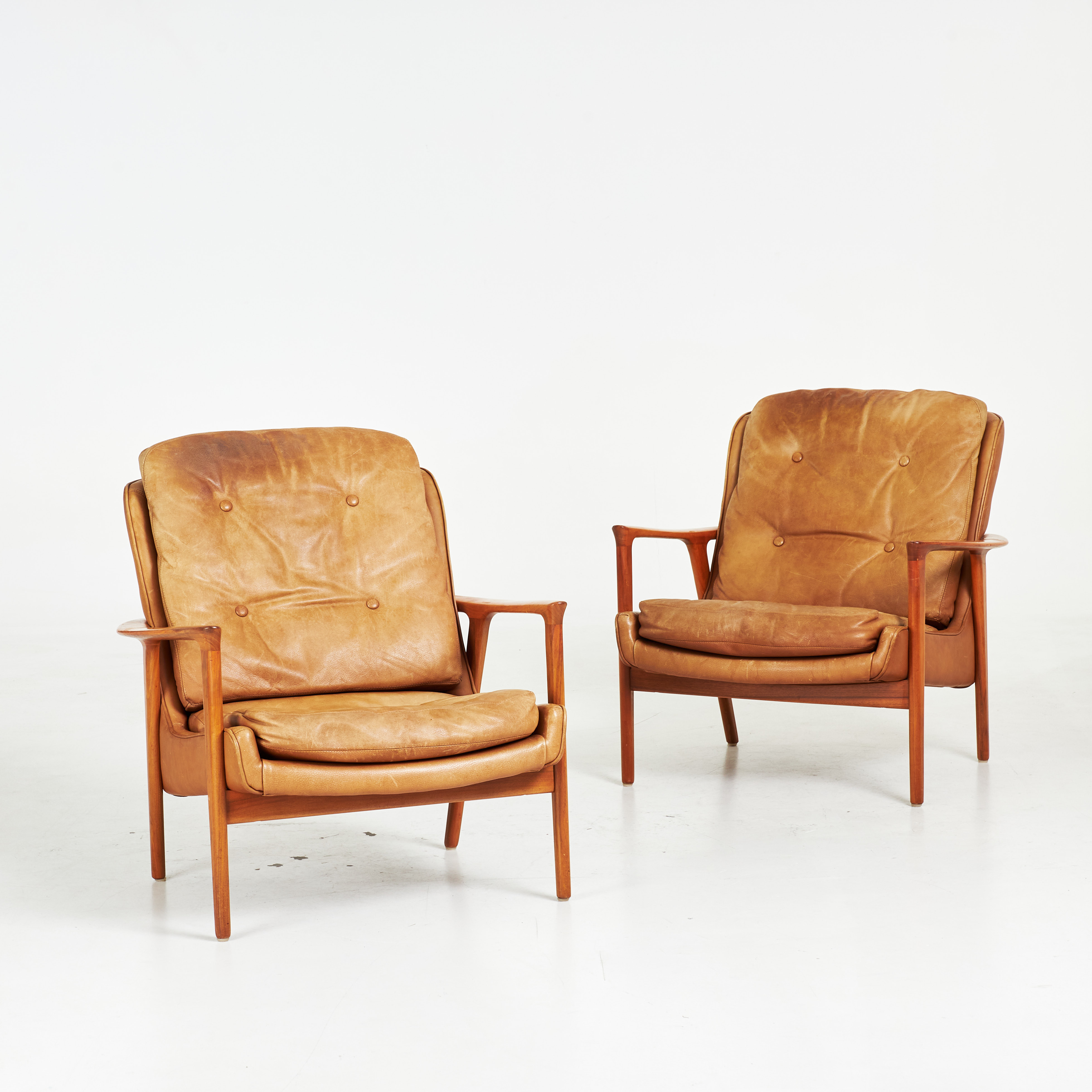 INGE ANDERSSON. Fåtöljer, 2 st., "Tunis", teakfanér, cognacsfärgad skinnklädsel, brickmärkta Bröderna Andersson, 1900-talets andra hälft.