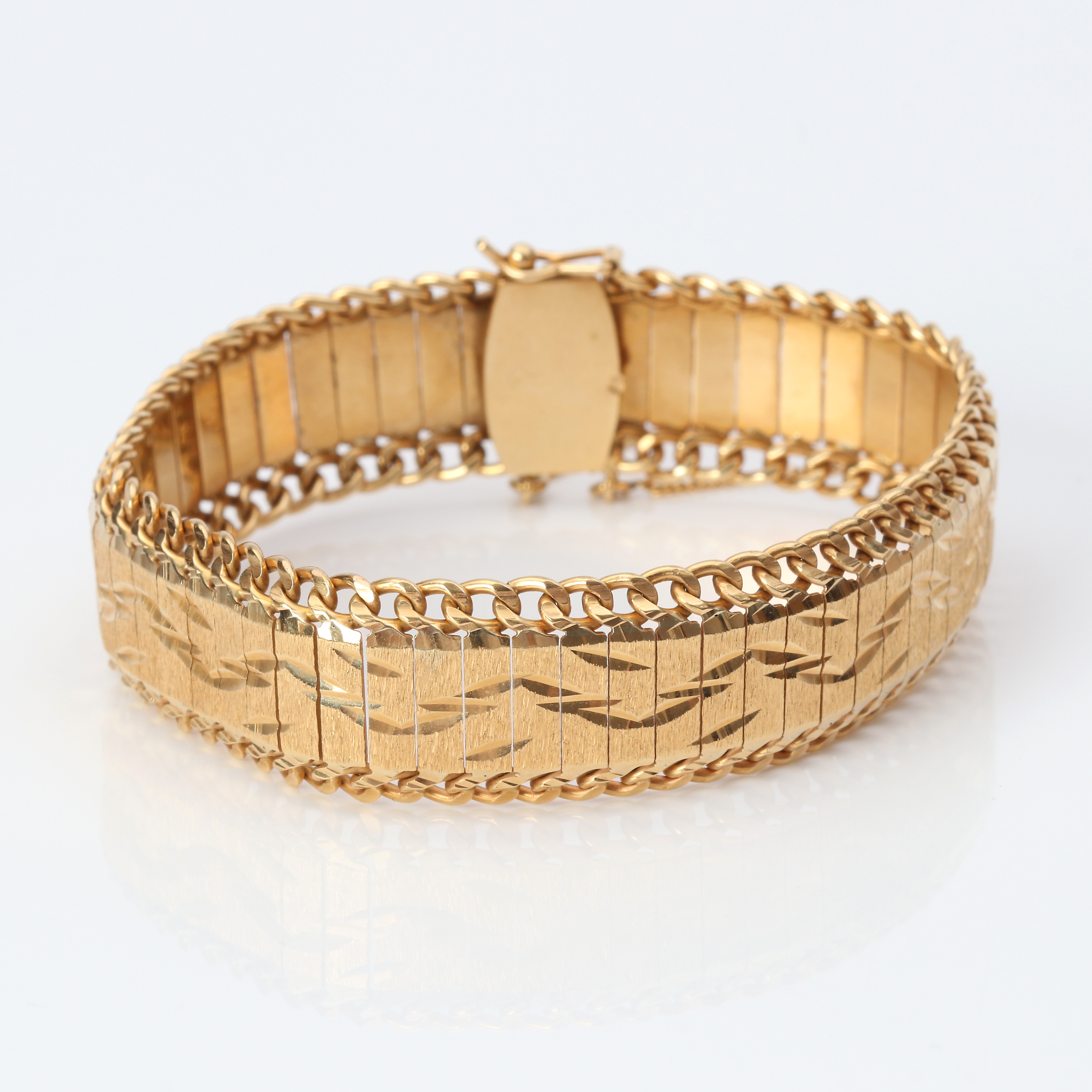 ARMBAND. 18k guld, ledat armband med satinerad yta och slipad dekor, vikt ca 38,8 gram.