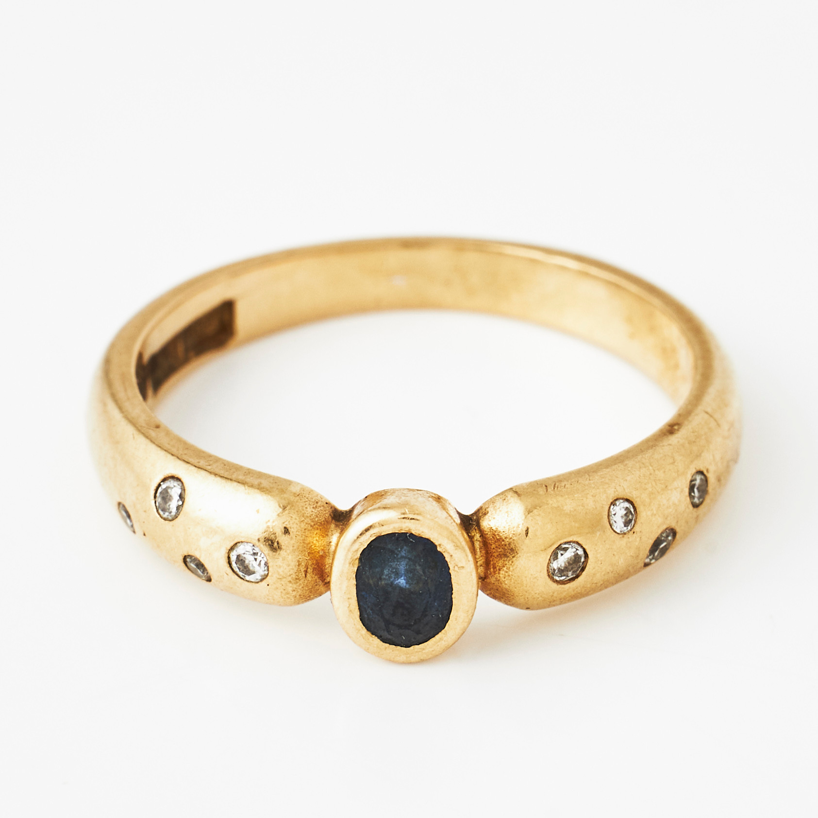 RING, 18 k guld, oval fasettslipad safir, sidodekorer med totalt 8 småbriljanter, Heribert Engelbert, Stockholm 1997.