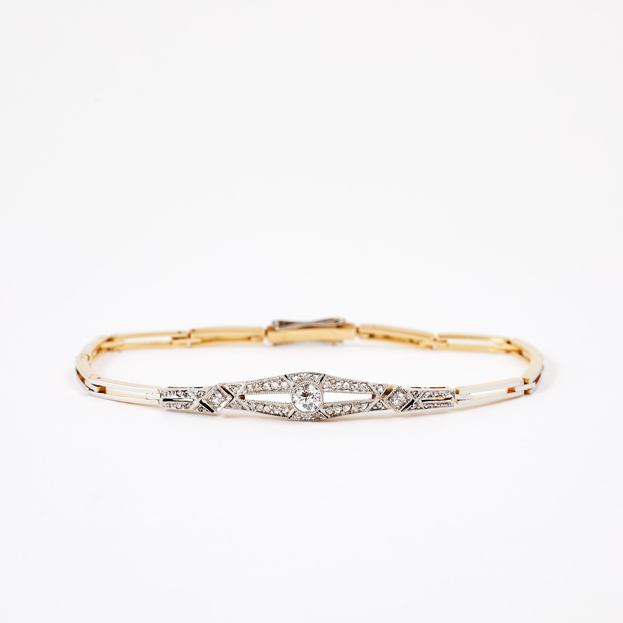 ARMBAND, guld/platina, omkring år 1900, 3 gammalslipade diamanter, totalt ca 0,28 ct, dekor av rosenslipade diamanter, milligrifferade kanter.