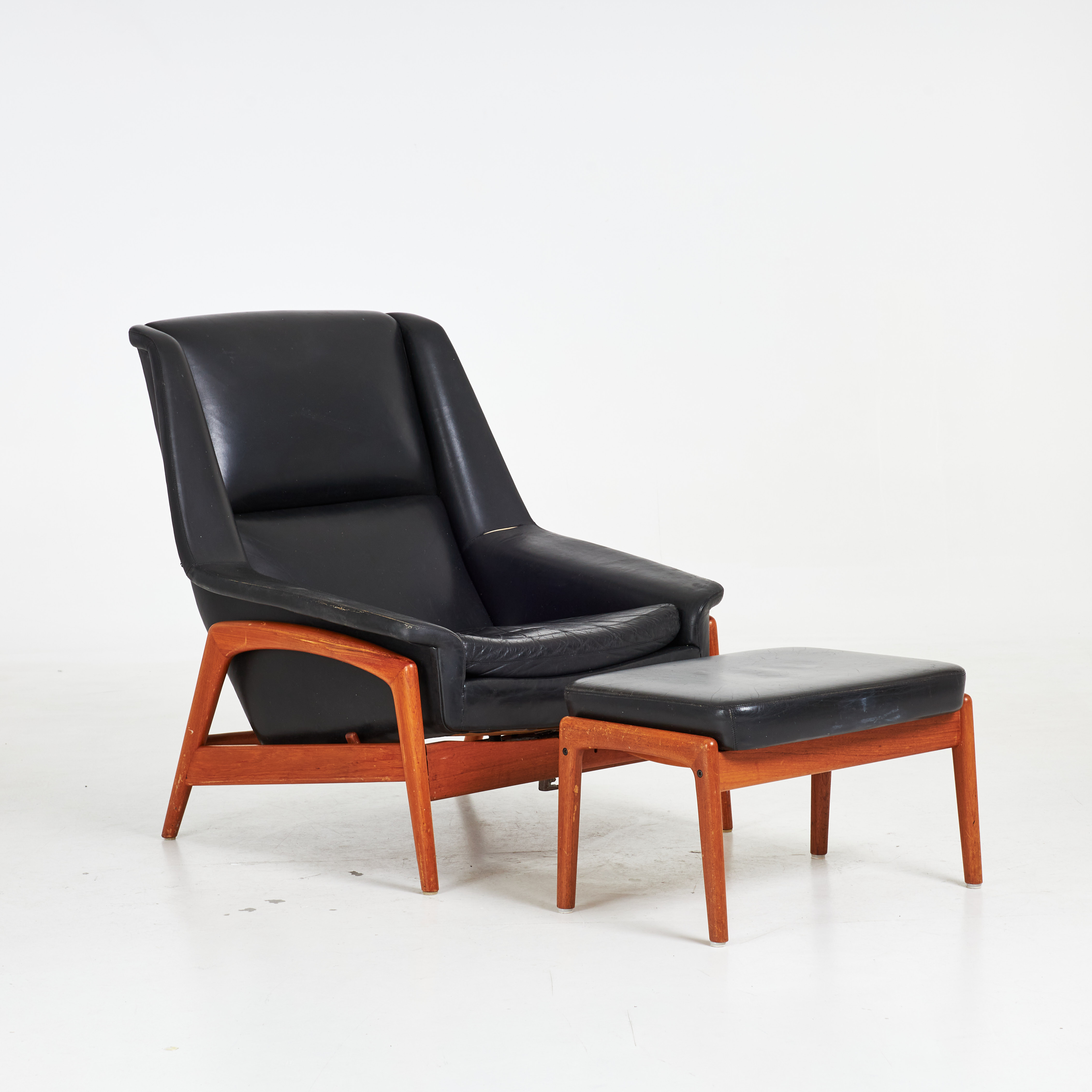 FOLKE OLSSON. Fåtölj med fotpall, 2 dlr, "Profil", stomme i teak, klädsel i läder, för DUX.