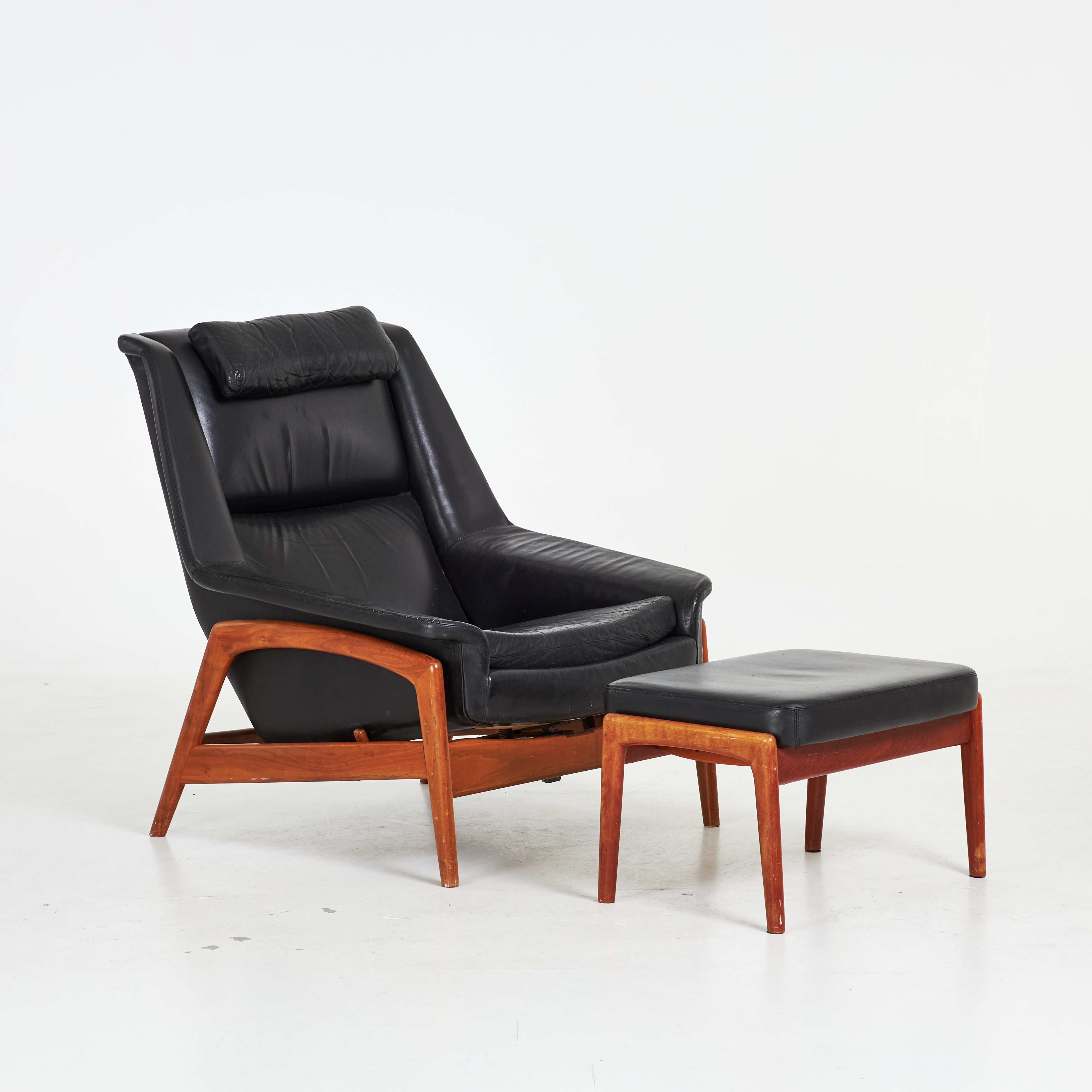 FOLKE OHLSSON. Fåtölj med fotpall, "Profil", Dux, 1950/60-tal, stomme i teak, helklädd i svart läder.