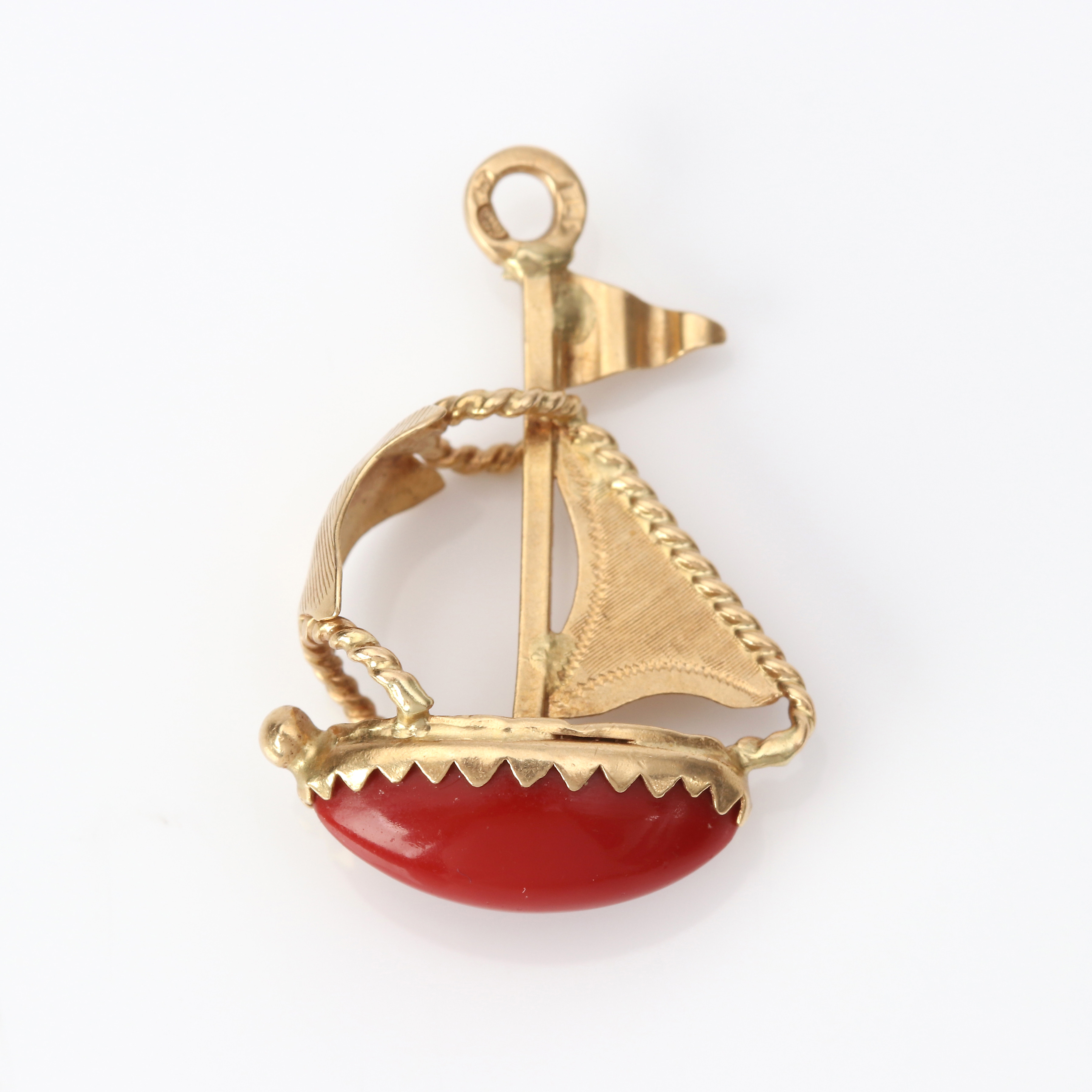 BERLOCK I FORM AV SEGELBÅT. 18k guld med en rödorange sten, totalvikt ca 2,8 gram.