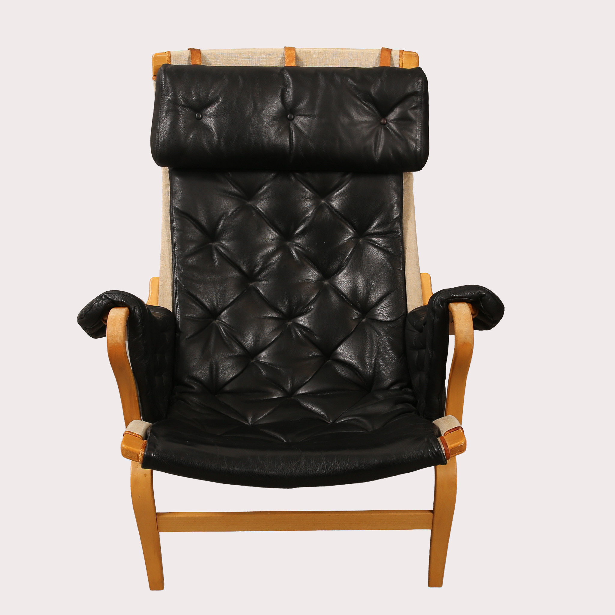 BRUNO MATHSSON. Fåtölj "Pernilla", DUX, stomme i bok med svart läderklädsel och nackkudde, 1900- talets andra hälft.