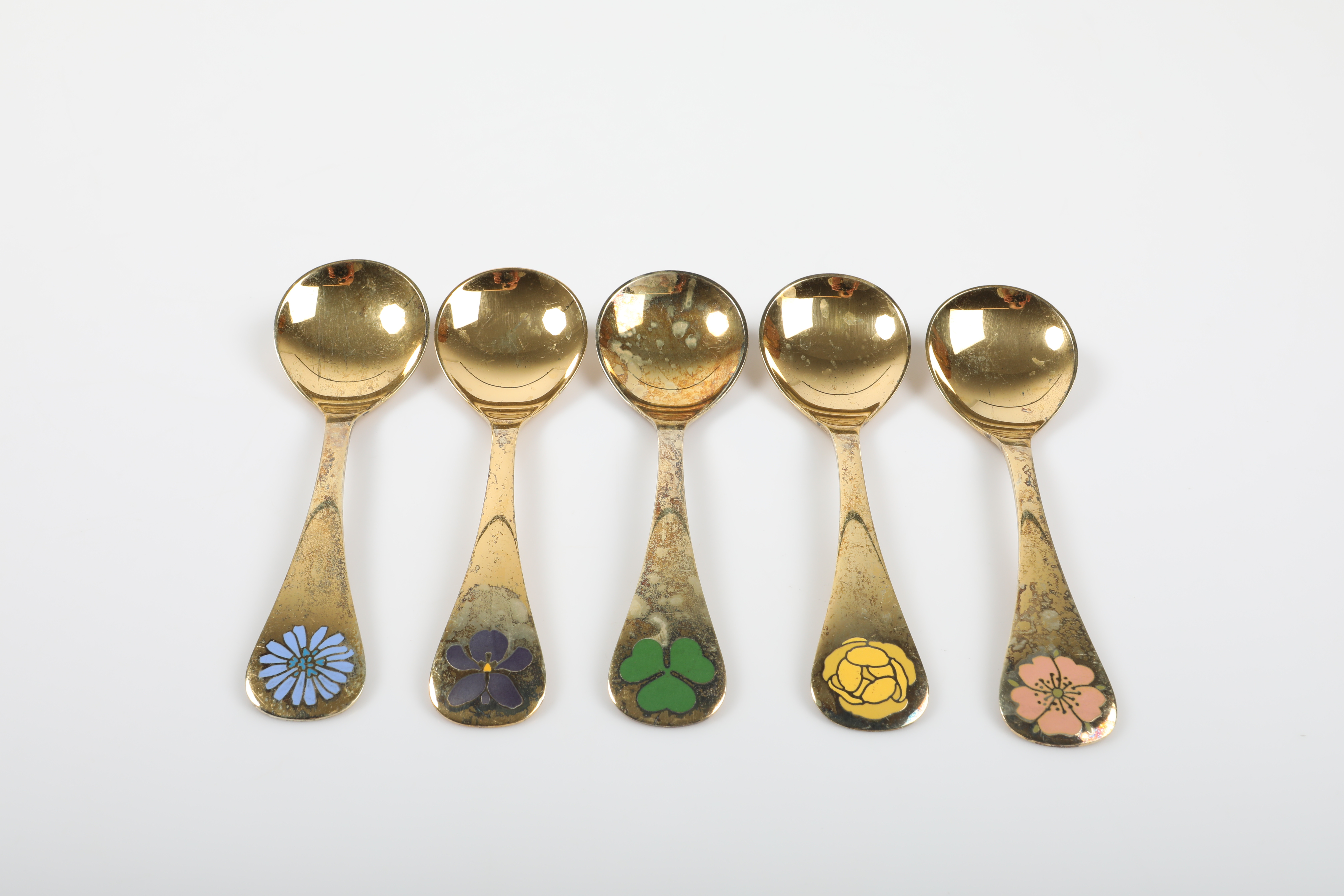 ÅRSSKEDAR, 5 stycken, förgyllt sterlingsilver med emaljerad dekor, Georg Jensen, Danmark, 1976-80.