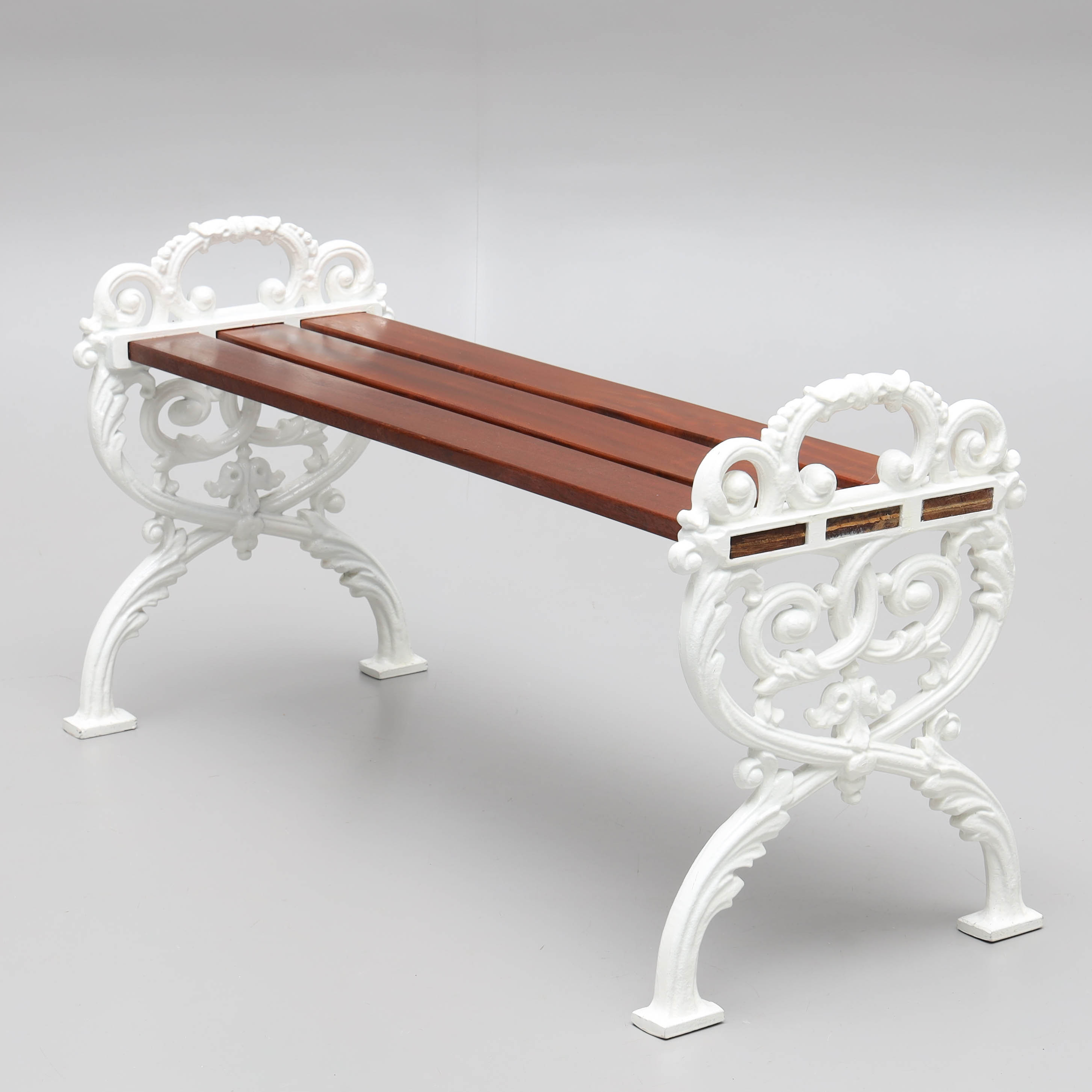 TRÄDGÅRDSBÄNK, sidostycken i gjuten aluminium, träribbor i mahognyfanér, ormbunke, 1900-tal.