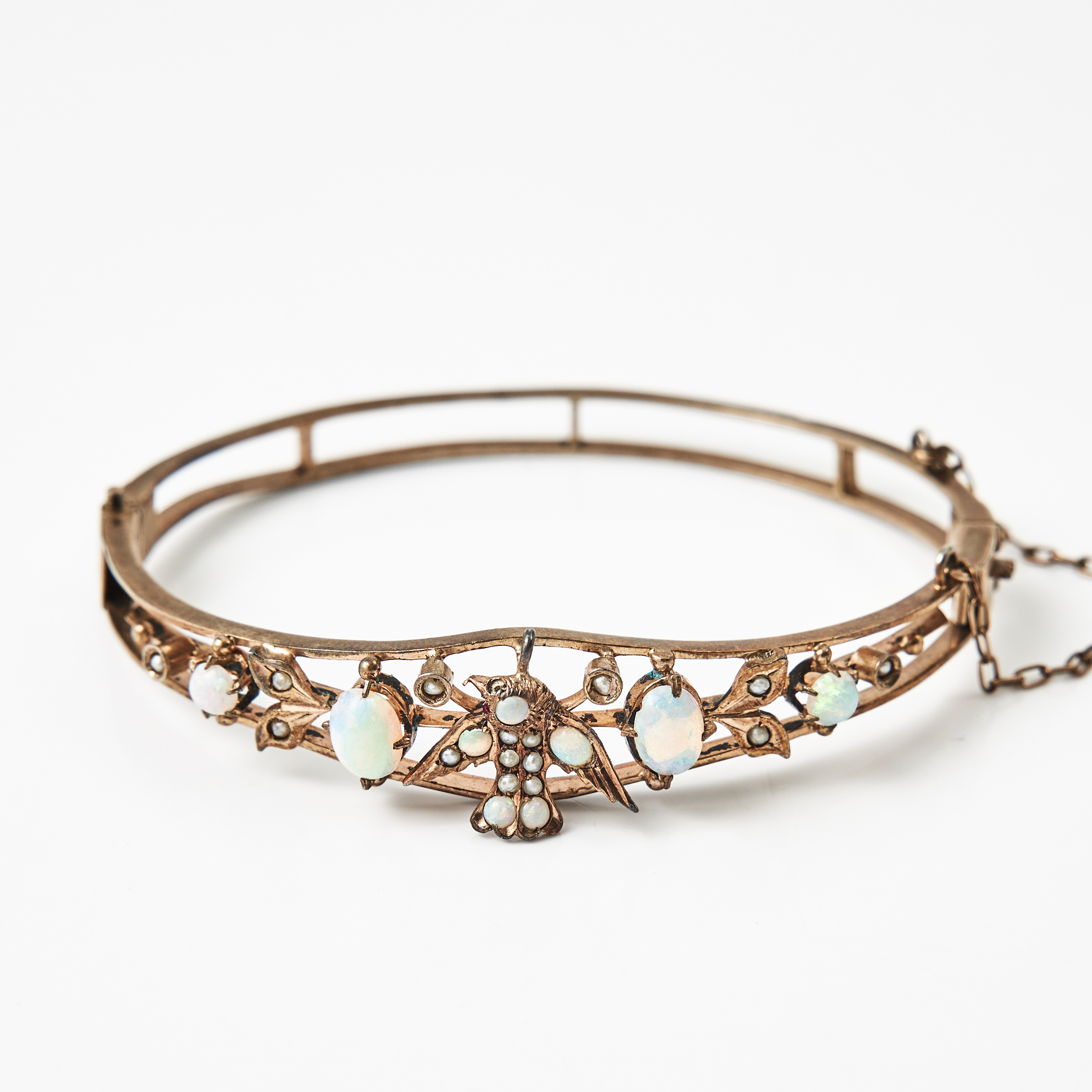 ARMRING, förgyllt silver, dekor med orientpärlor och mitten i form av en fågel samt cabochonslipade opalliknande stenar, omkring 1900.