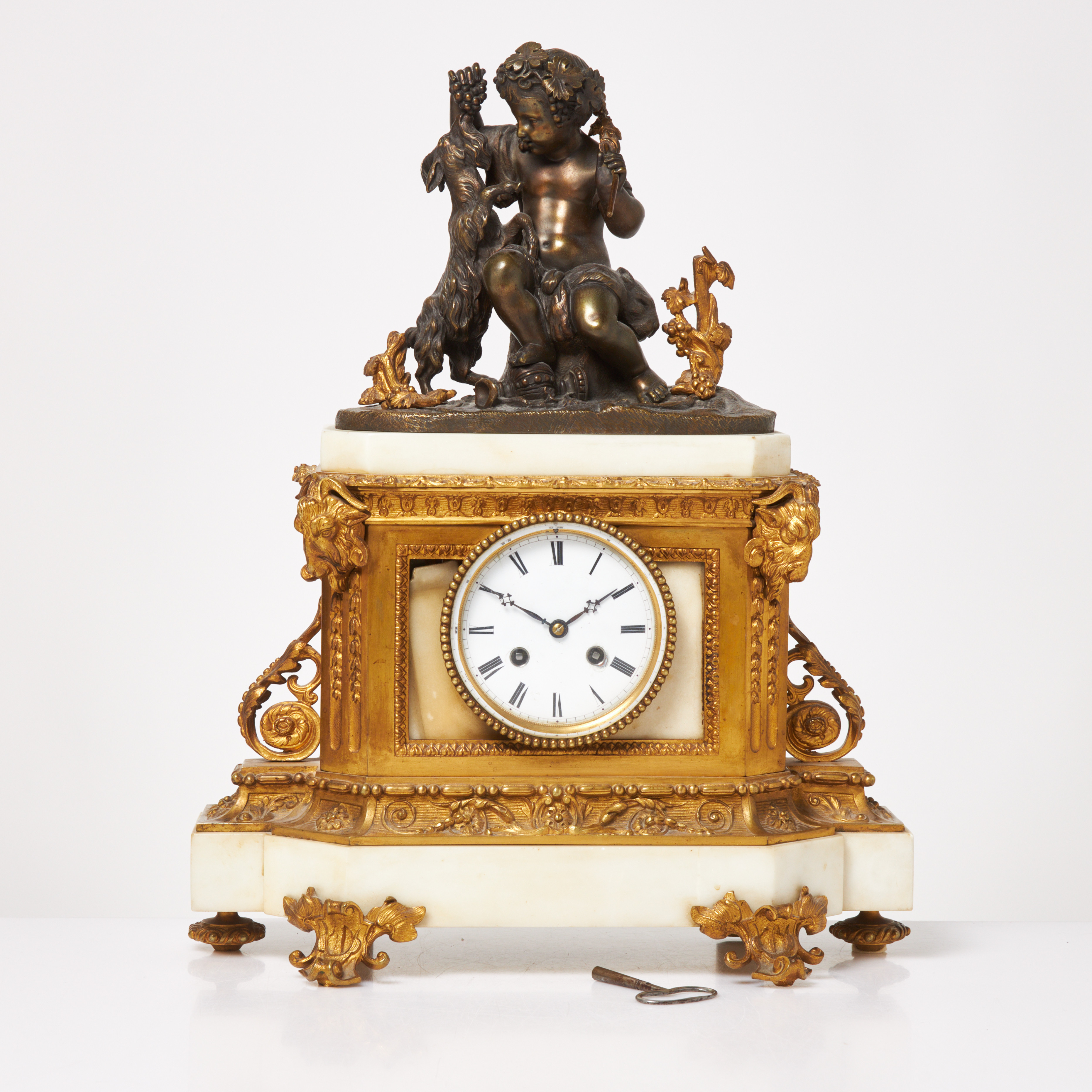 BORDSPENDYL, 1800-tal, dekor av bl.a. putti och get, gulmetall, stensockel, emaljerad urtavla med romerska siffror, sannolikt Frankrike.