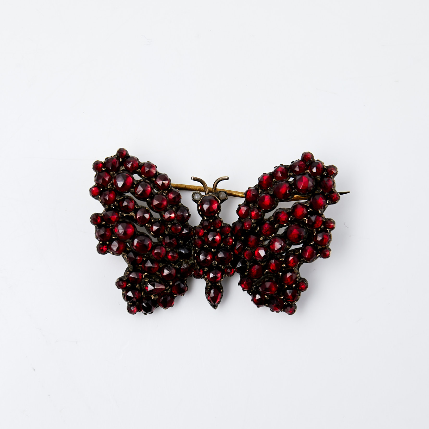 BROSCH, förgylld metall, 1800-talets mitt, rosenslipade granater, ögon av orientaliska pärlor, i form av fjäril.