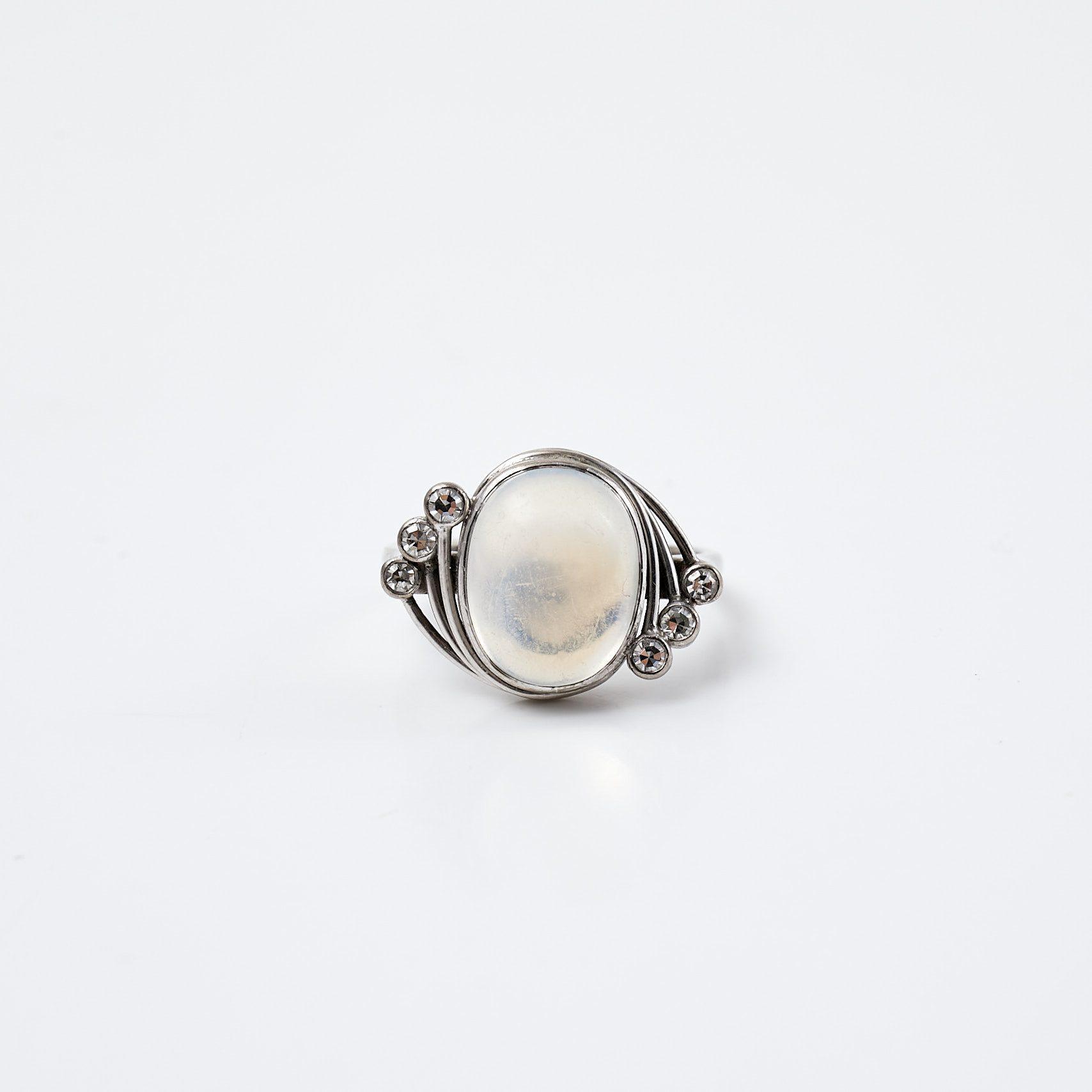 RING, 18 k vitguld, 1 cabochonslipad månsten, 6 åttkantslipade diamanter, totalt ca 0,15 ct, Hallbergs Guldsmeds Ab C G, Stockholm, 1957.