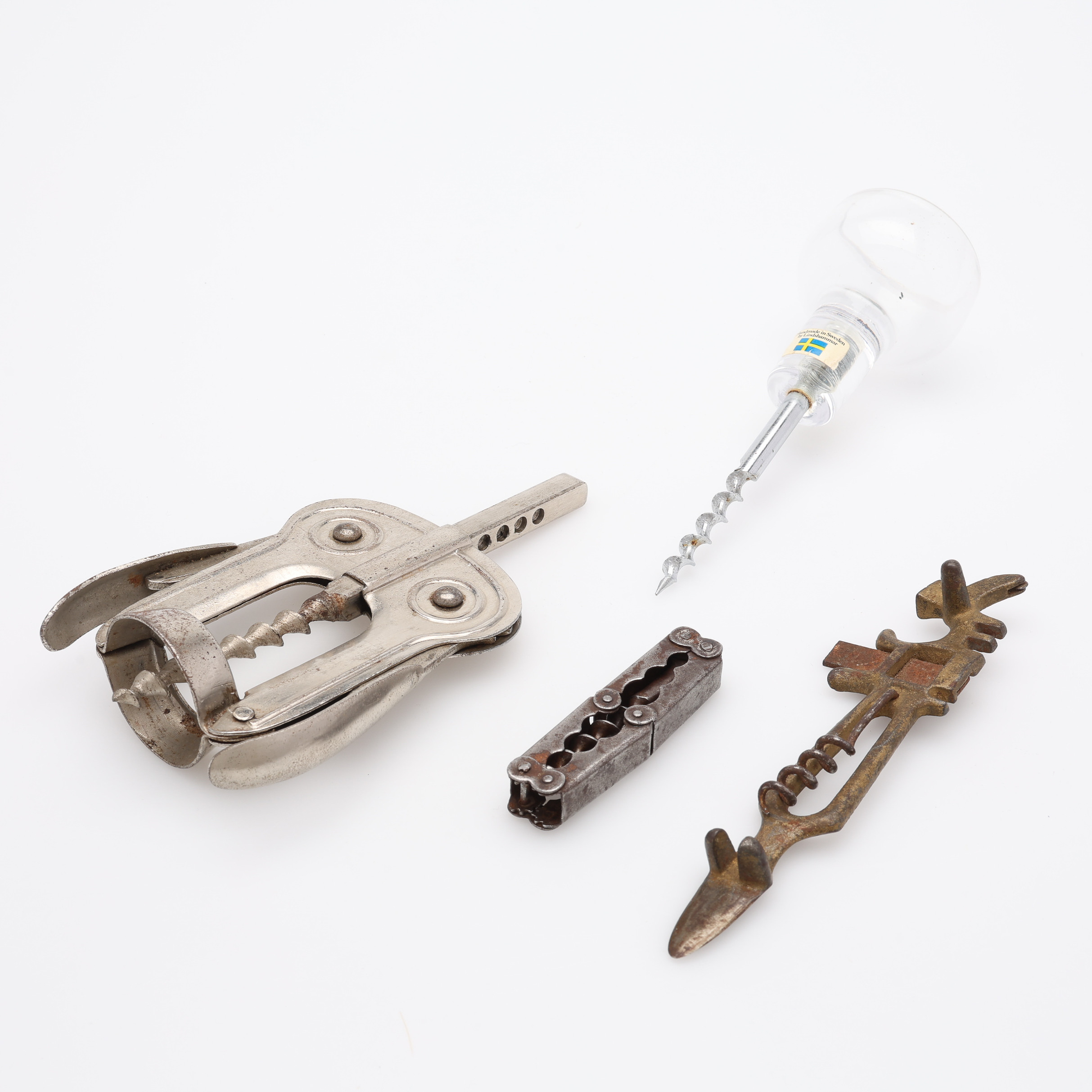 FYRA UDDA KORKSKRUVAR, en hollweg-typ, en från Lindshammars Glasbruk, en omärkt i förnicklat stål, samt en Woodward Corkscrew.