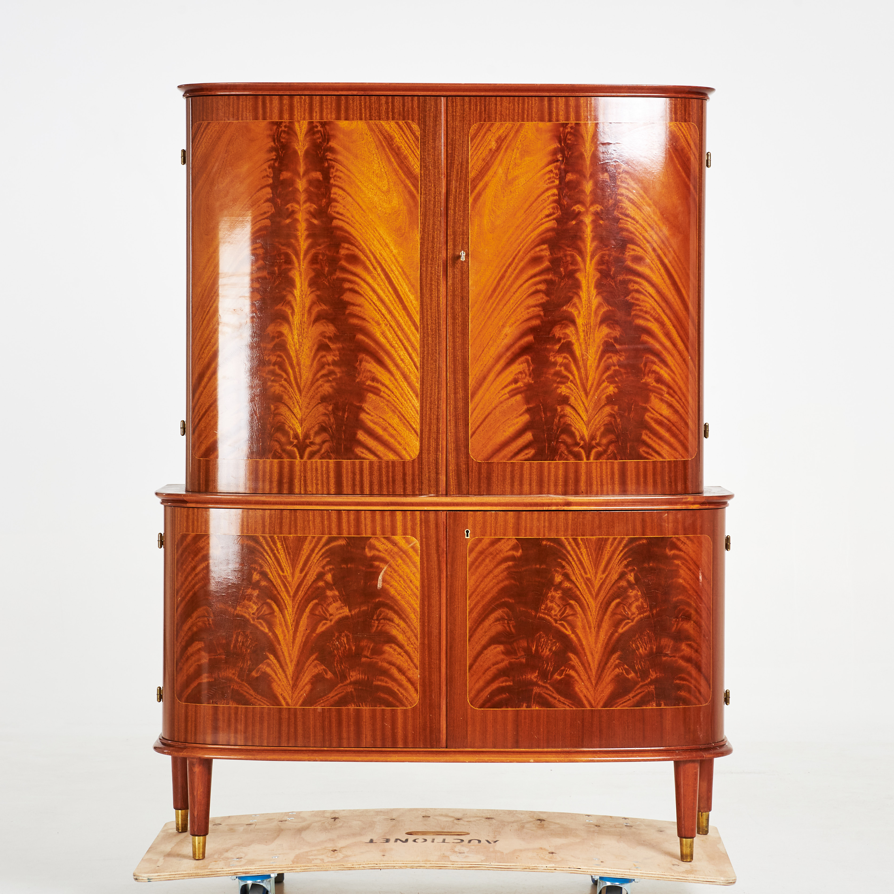 SKÅP. Swedish Modern, 1940/50-tal, fanérad med pyramidmahogny, välvd form, invändigt med justerbara hyllplan samt tre draglådor i underskåp, mässingsbeklädda benavslut.