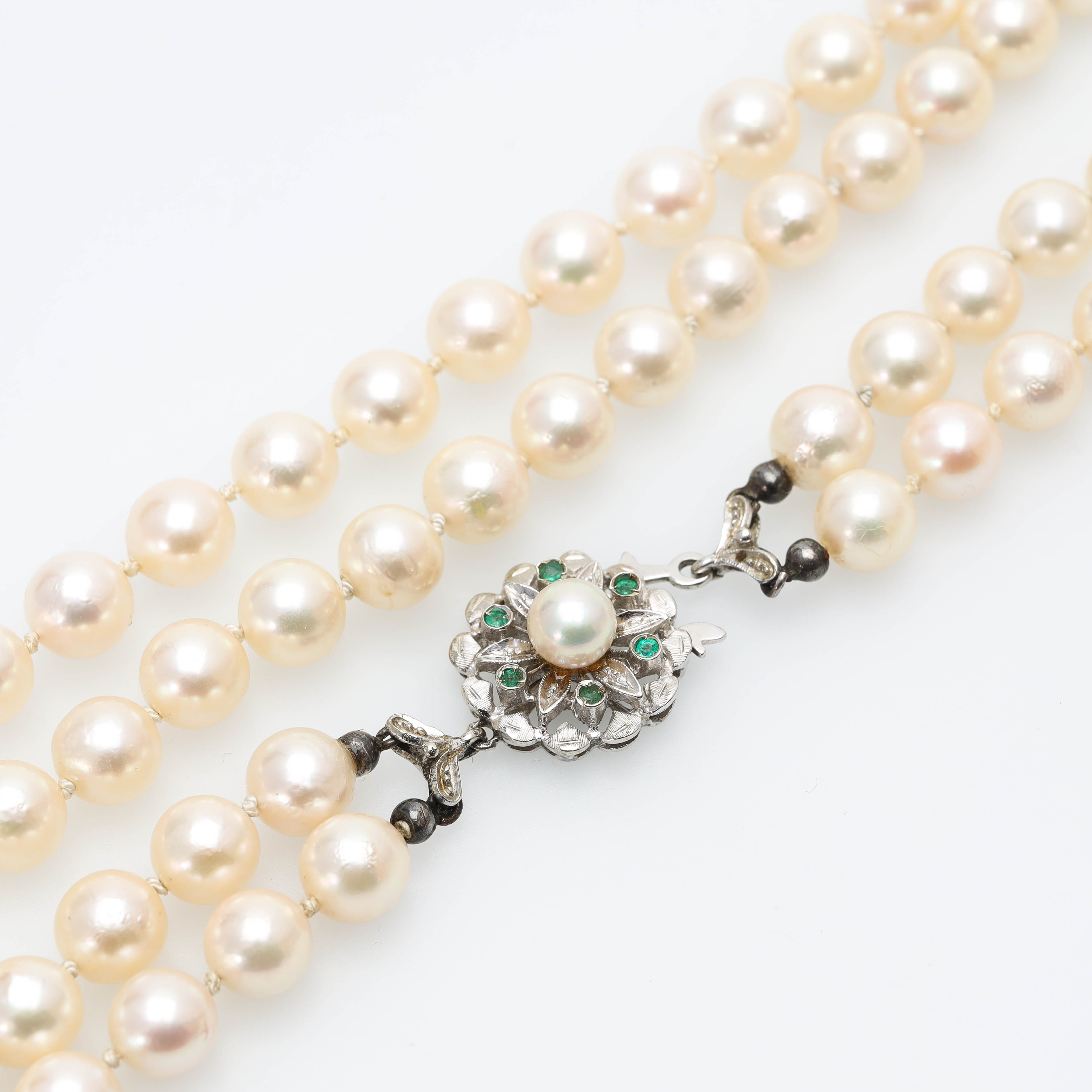 COLLIER, lås i 18 k vitguld med smaragder, tvåradigt med odlade saltvattenspärlor.
