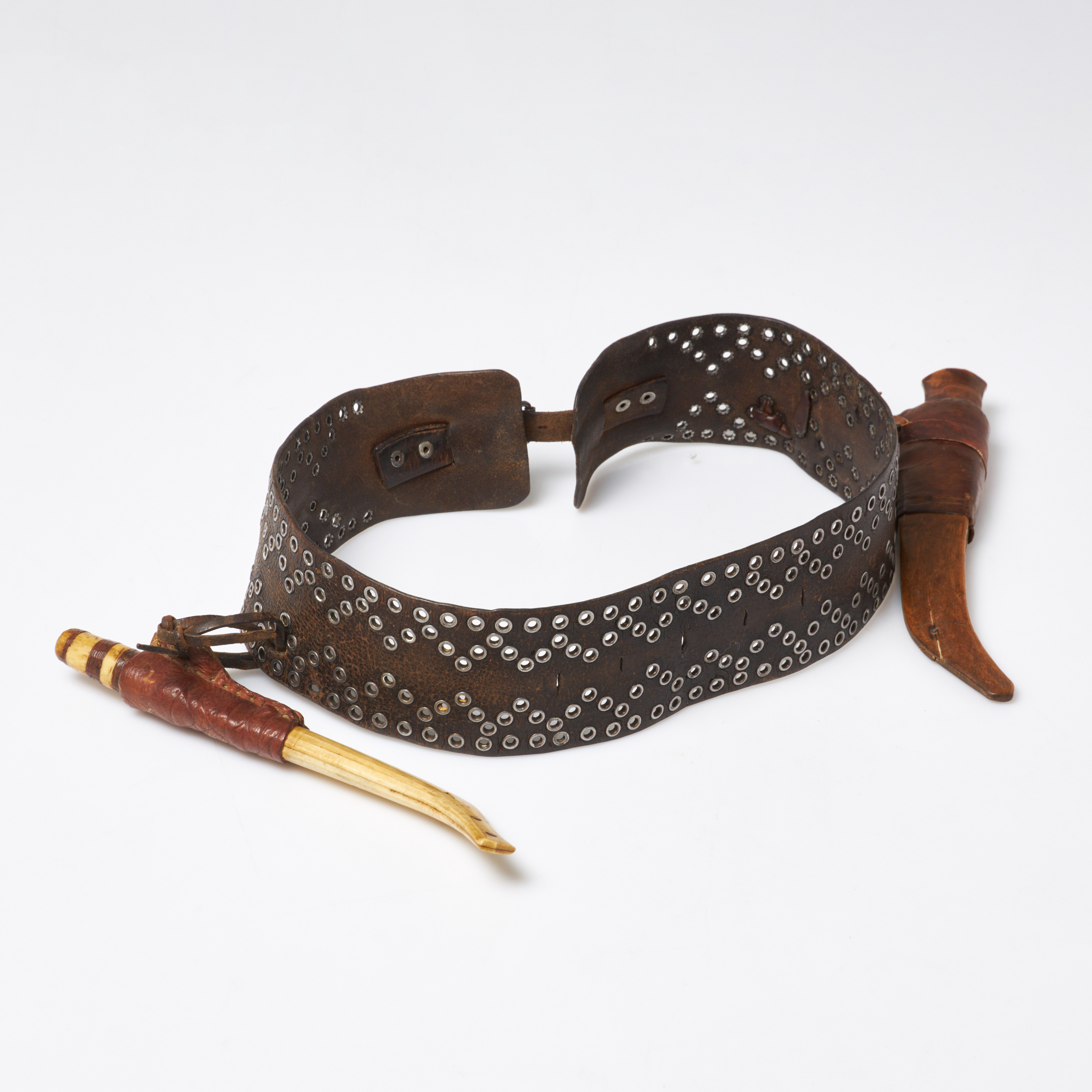 SAMISKT KNIVBÄLTE samt två knivar, 1900-talets första hälft, bälte i läder med nitad dekor.