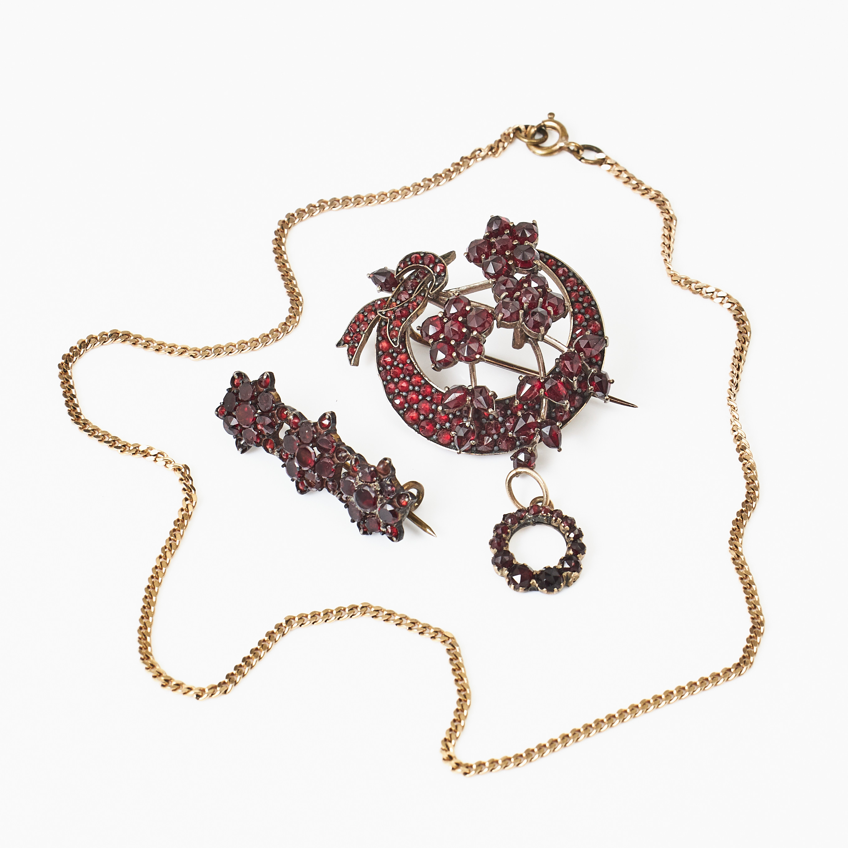 BROSCHER, 2 st., varav en i form av halvmåne och stjärnor föreställande stjärnfall, s.k. Celestial jewel, HÄNGE, oädel metall, fasettslipade äldre granater, 1800-talets senare del.