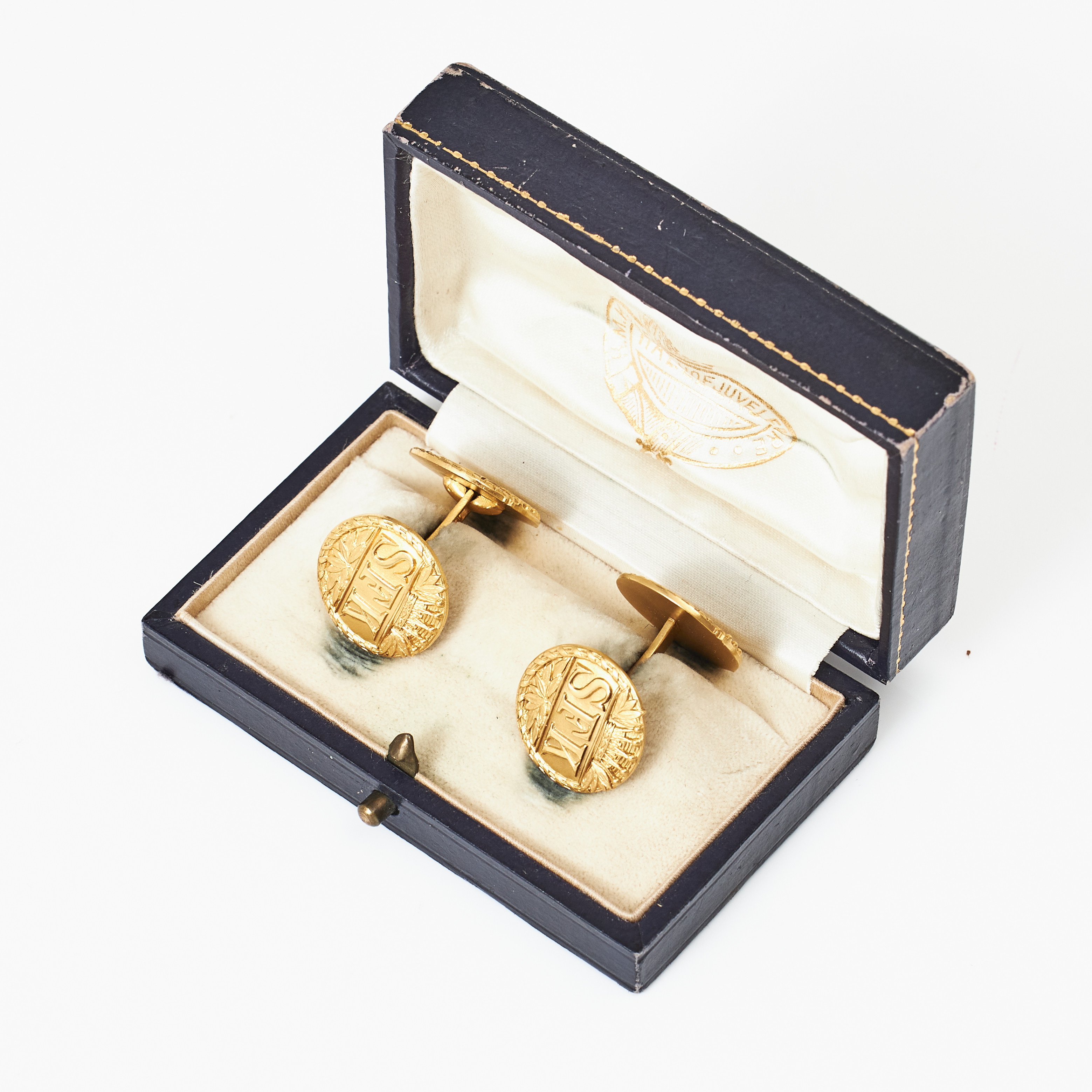 MANSCHETTKNAPPAR, 1 par, 18 k guld, runda manschettbrickor med präglad dekor av bokstäverna SKF (Stockholms Fältrittklubb) under hertigkrona och krans av fascesstav, C.G.Hallberg, Stockholm 1917.