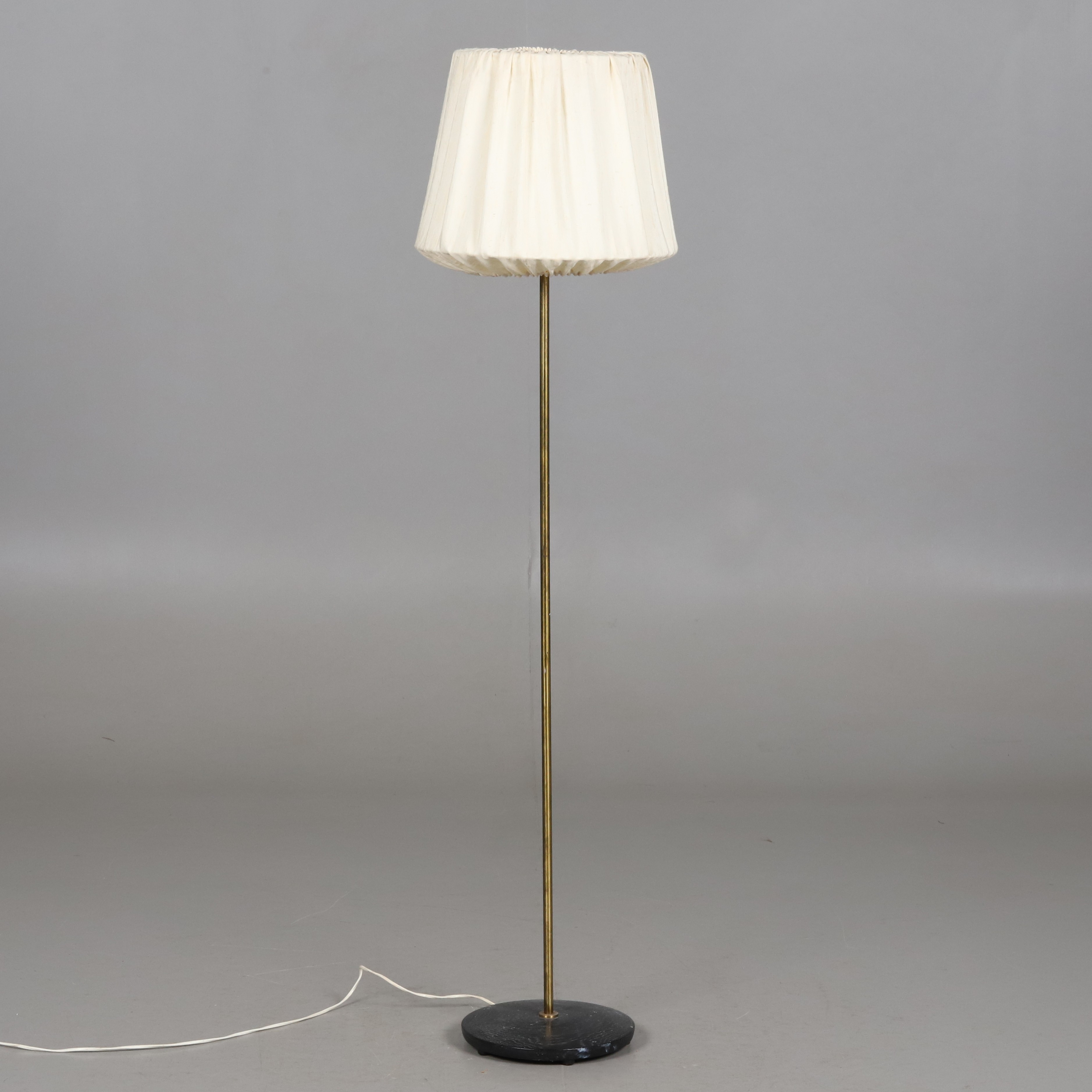 GOLVLAMPA. Stomme i mässing med träfot och tygskärm.