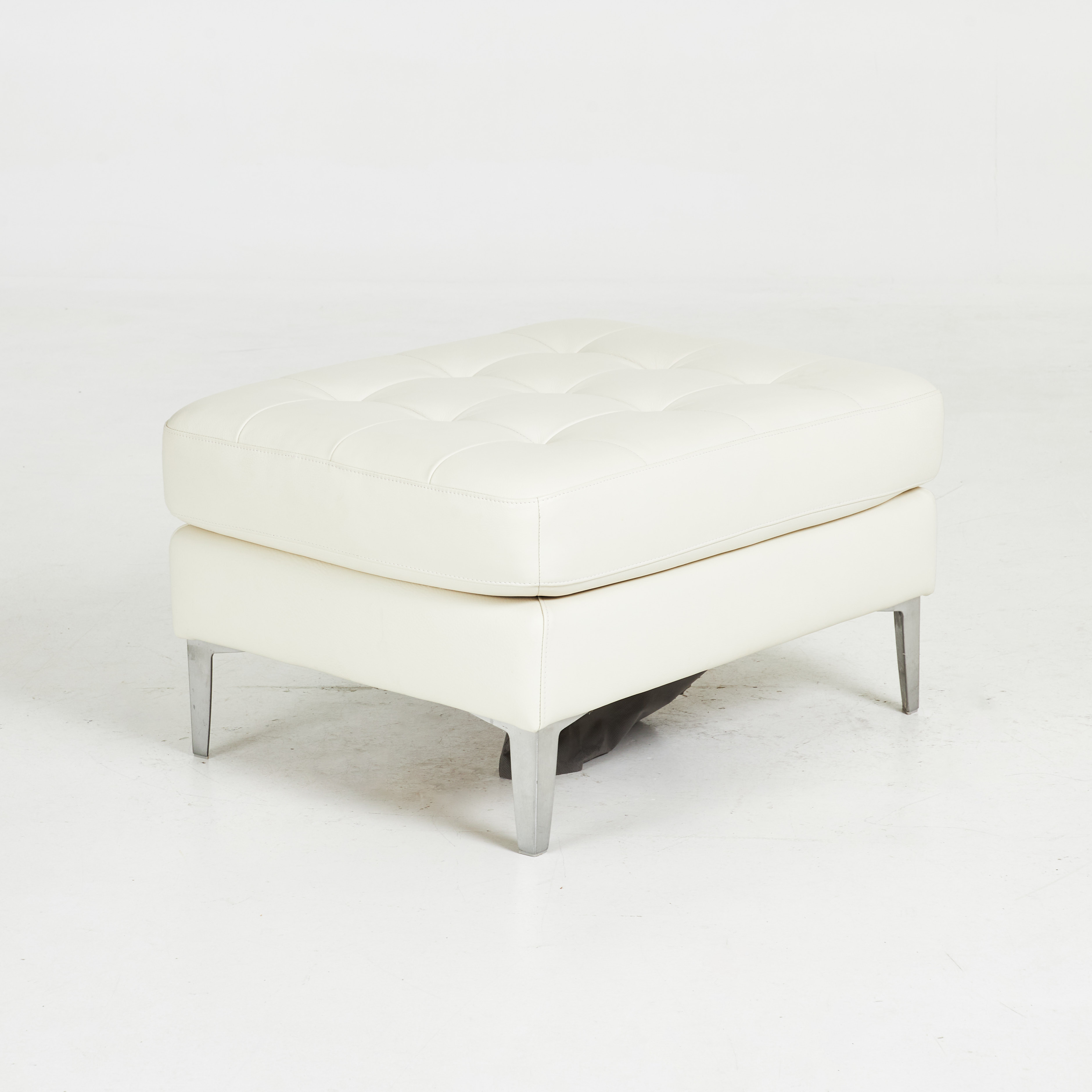 SITTPUFF. Samtida, ben i kromat metall, klädd i djuphäftad ljust skinn.