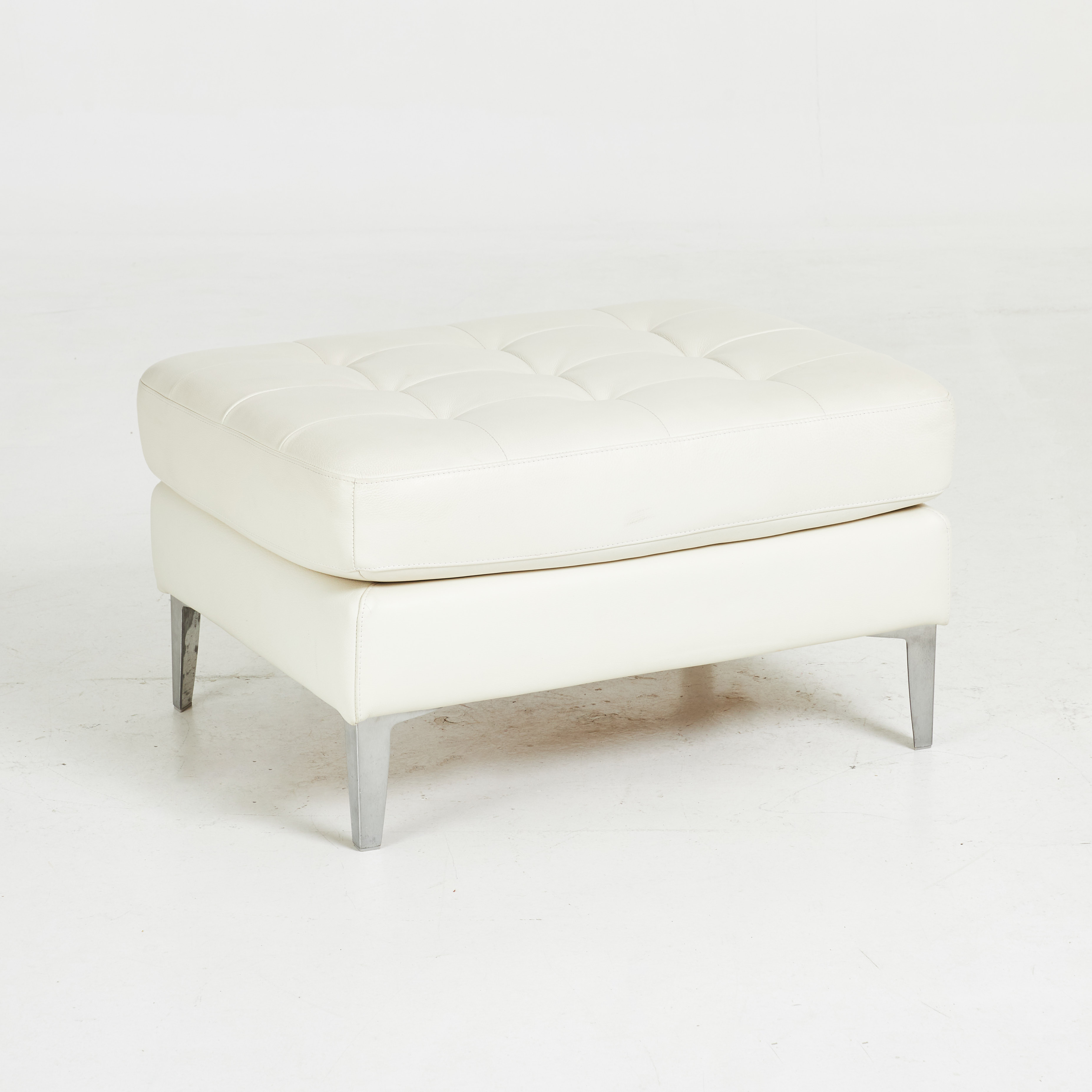 SITTPUFF. Samtida, ben i kromat metall, klädd i djuphäftad ljust skinn.