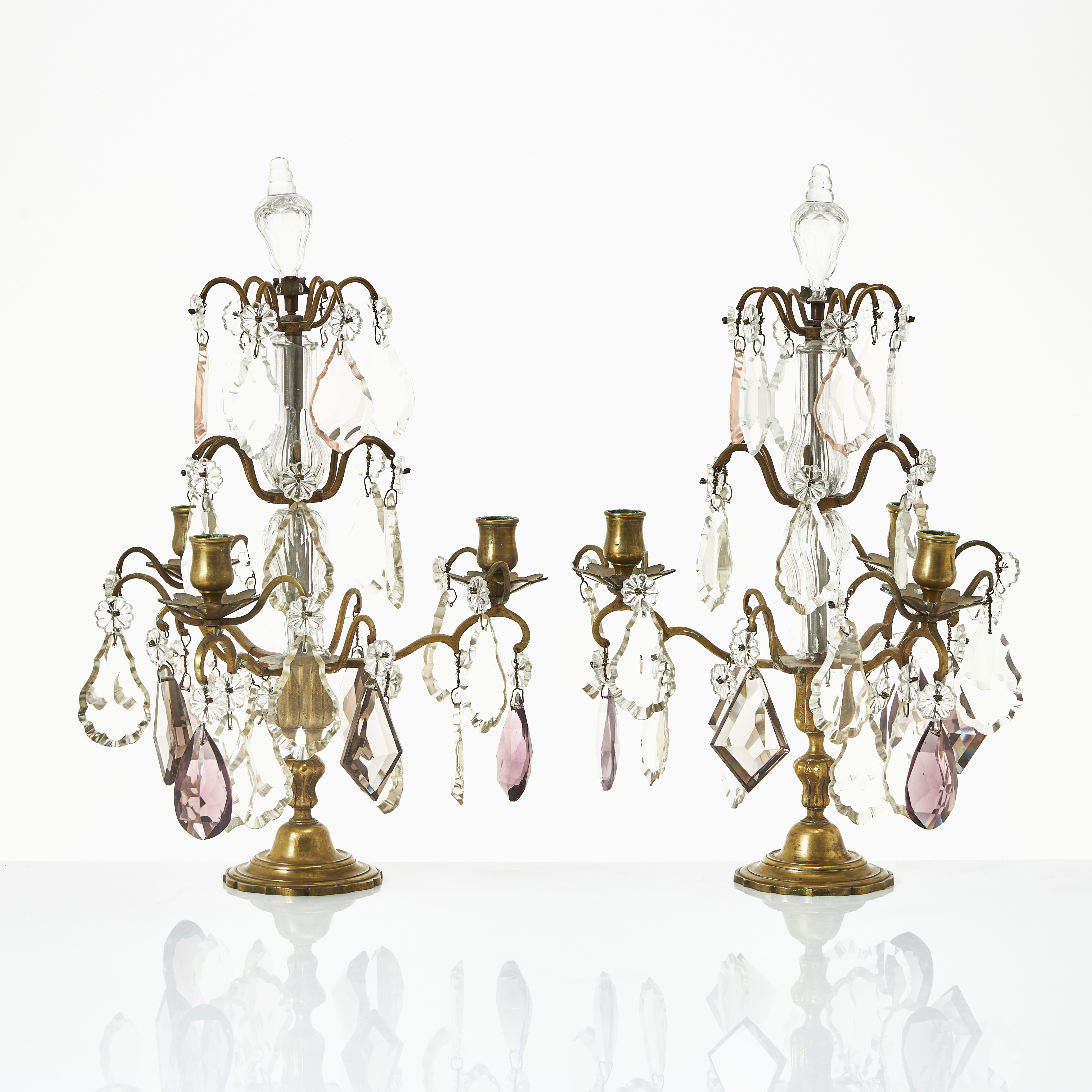 BORDSLYSTRAR, ett par, stomme i brons, 1800-tal, Louis Seizestil, för tre ljus, behängda med olikslipade prismor, vissa färgade.