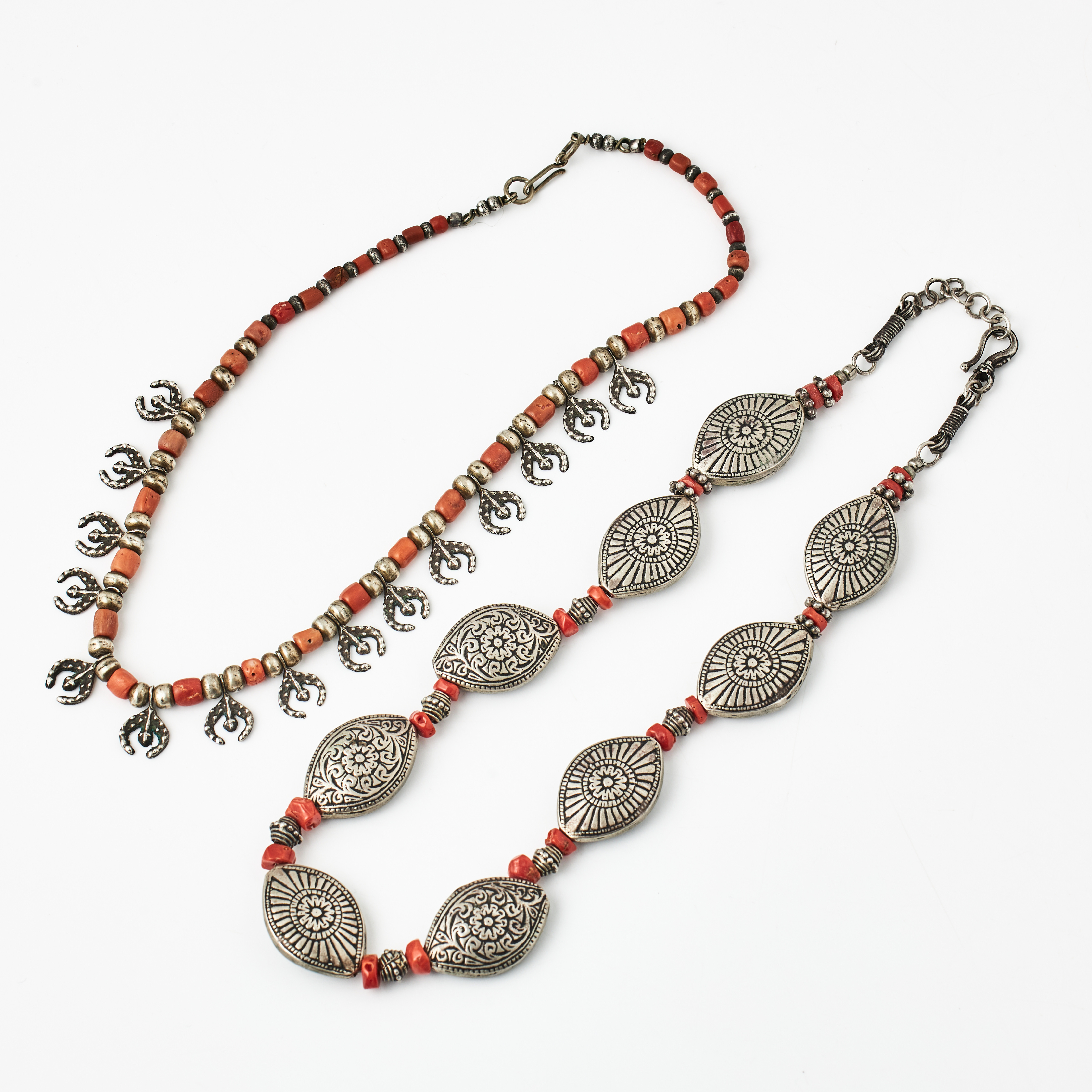 HALSBAND, 2 st., låghaltigt silver, dekor med koraller, ovala delar med två olika dekorer varav ett med hästskoformade dekordelar, troligen nordafrika, 1900-tal.