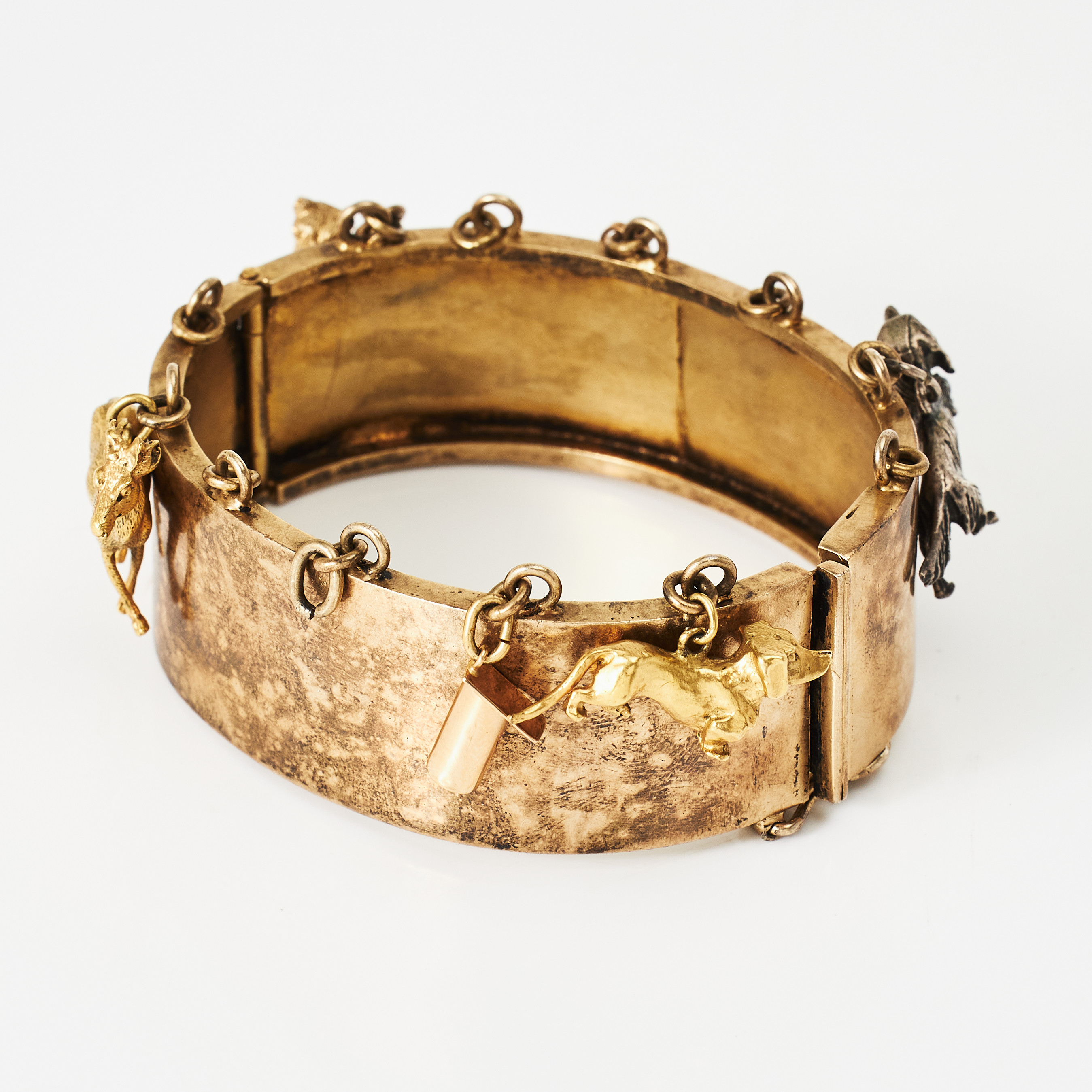 ARMRING, förgyllt silver, öglor för berlocker, bl a i form av fågelholk, långhårig tax (ej förgylld), armringen stämplad Bertil Blomqvist, Stockholm 1955.