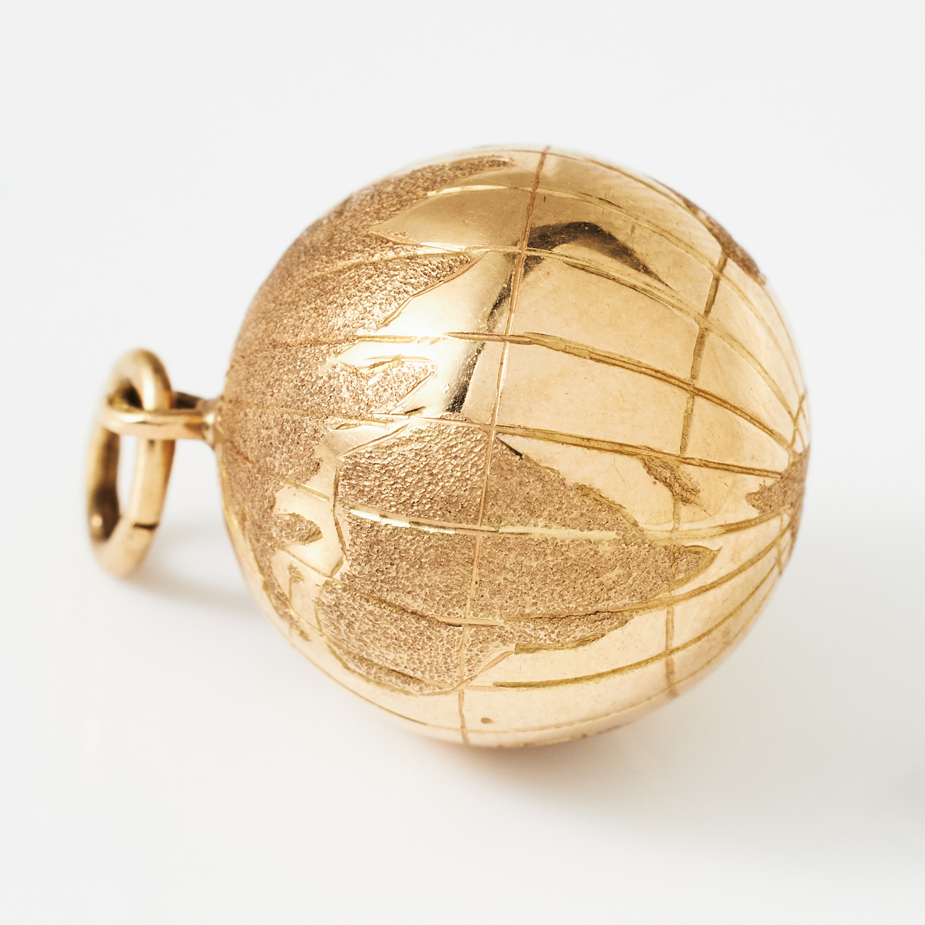BERLOCK, 18 k guld, bollformad, graverad dekor av världsdelarna.