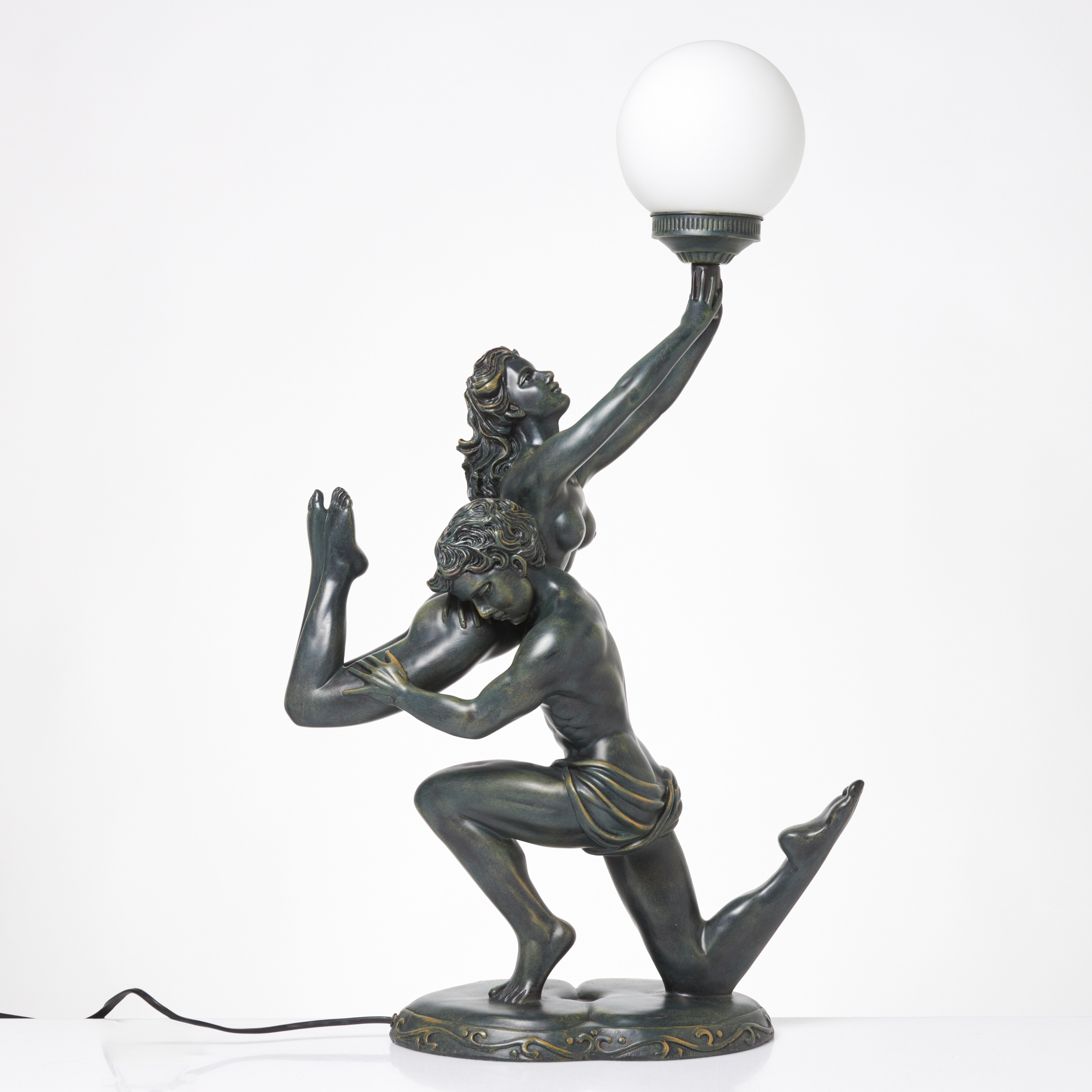 BORDSLAMPA. Skulptural botten föreställande par, patinerad metall, kupa i vittunderfångsglas, samtida tillverkning.