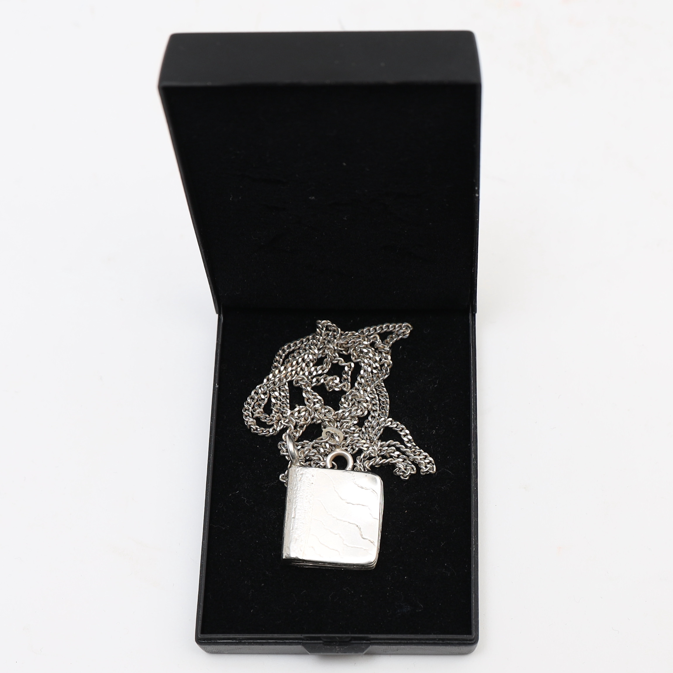 KARIN FERNER. Halsband med hänge, föreställande bok.