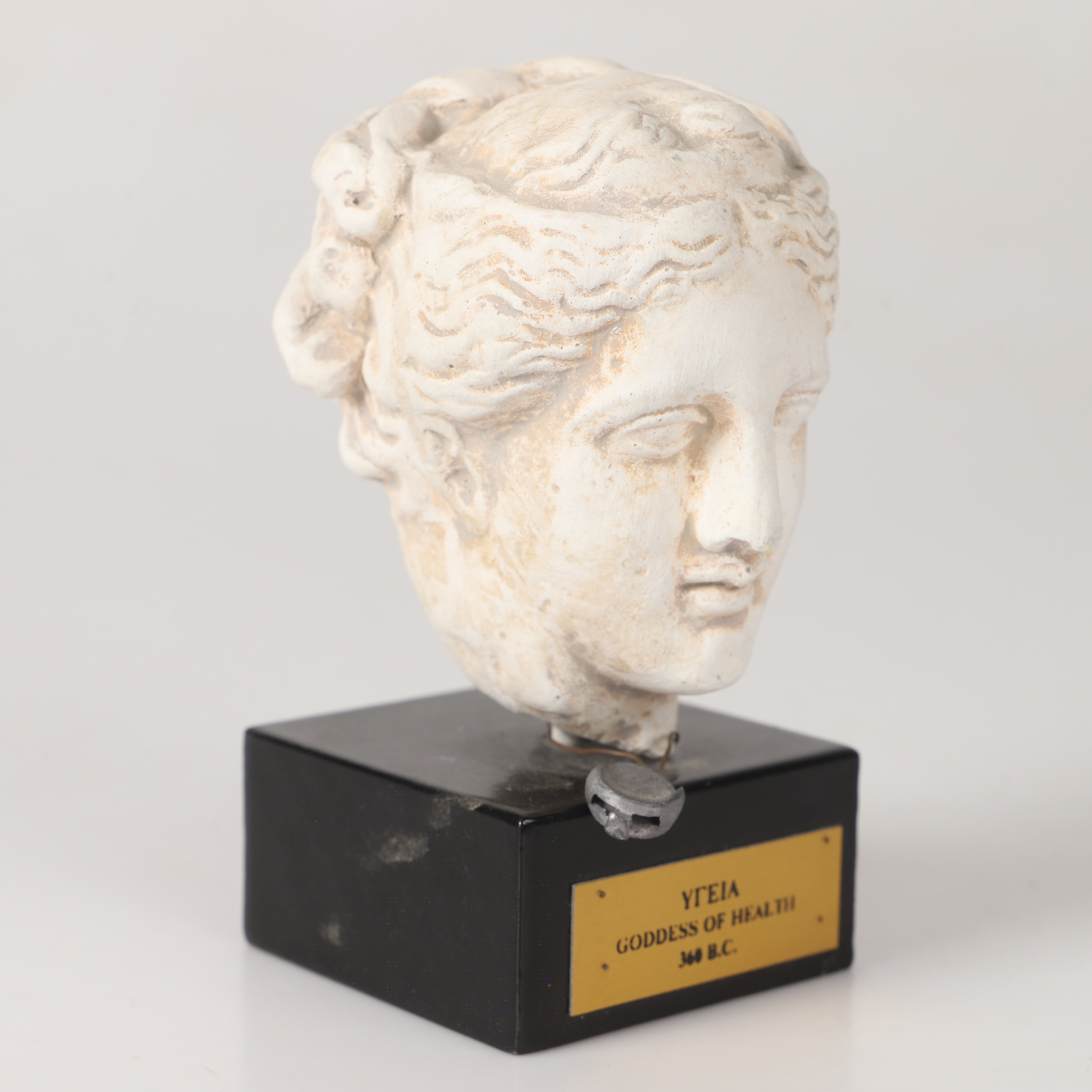 FIGURIN, "Hygieia", keramik på träsockel, 1900-tal.