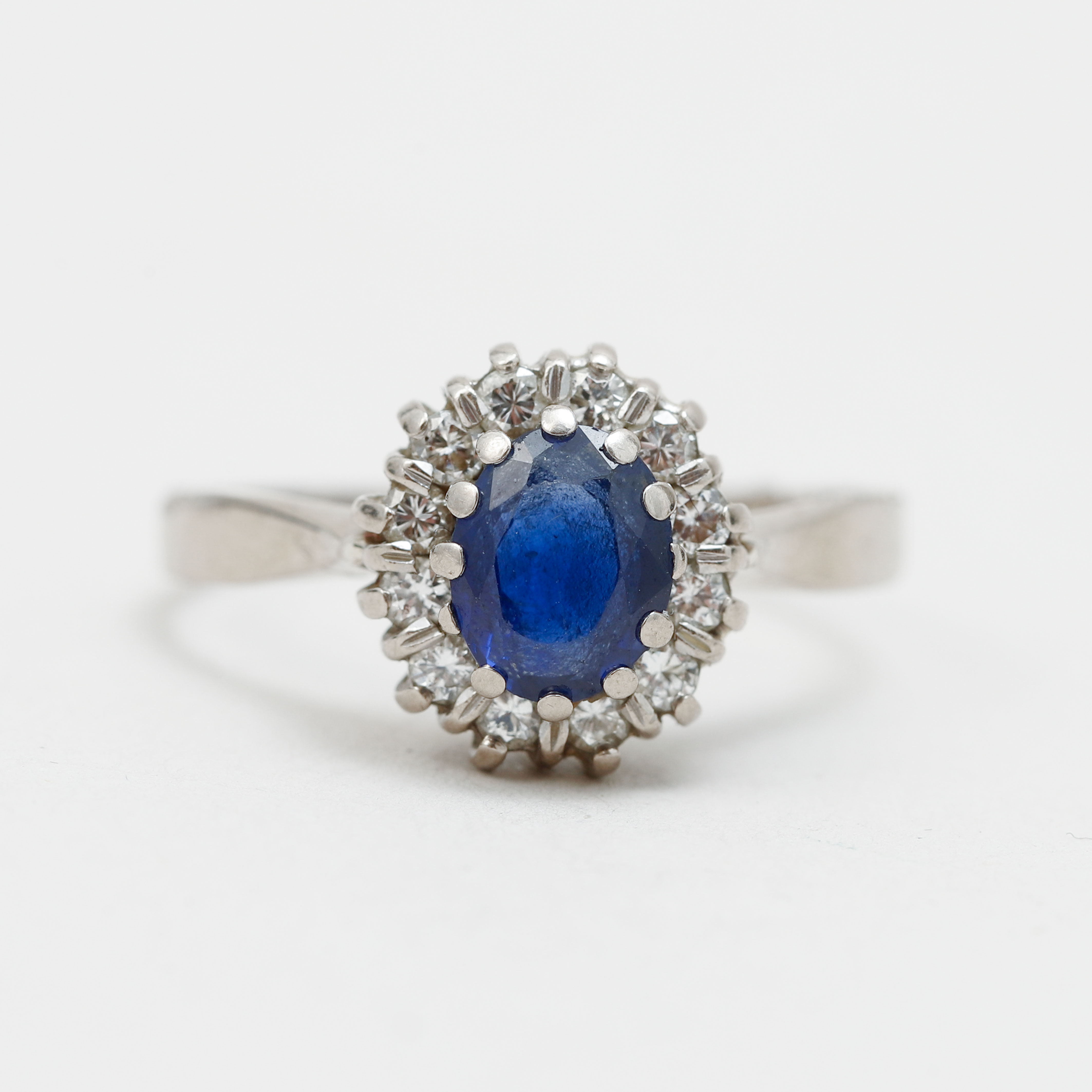 CARMOSÉRING, 18k vitguld med en safir, enligt gravyr 1,25 ct, och 12 st diamanter, enligt gravyr totalt 0,24 ct RVVS. Jarl Sandin Göteborg. Vikt ca 3,3 g.