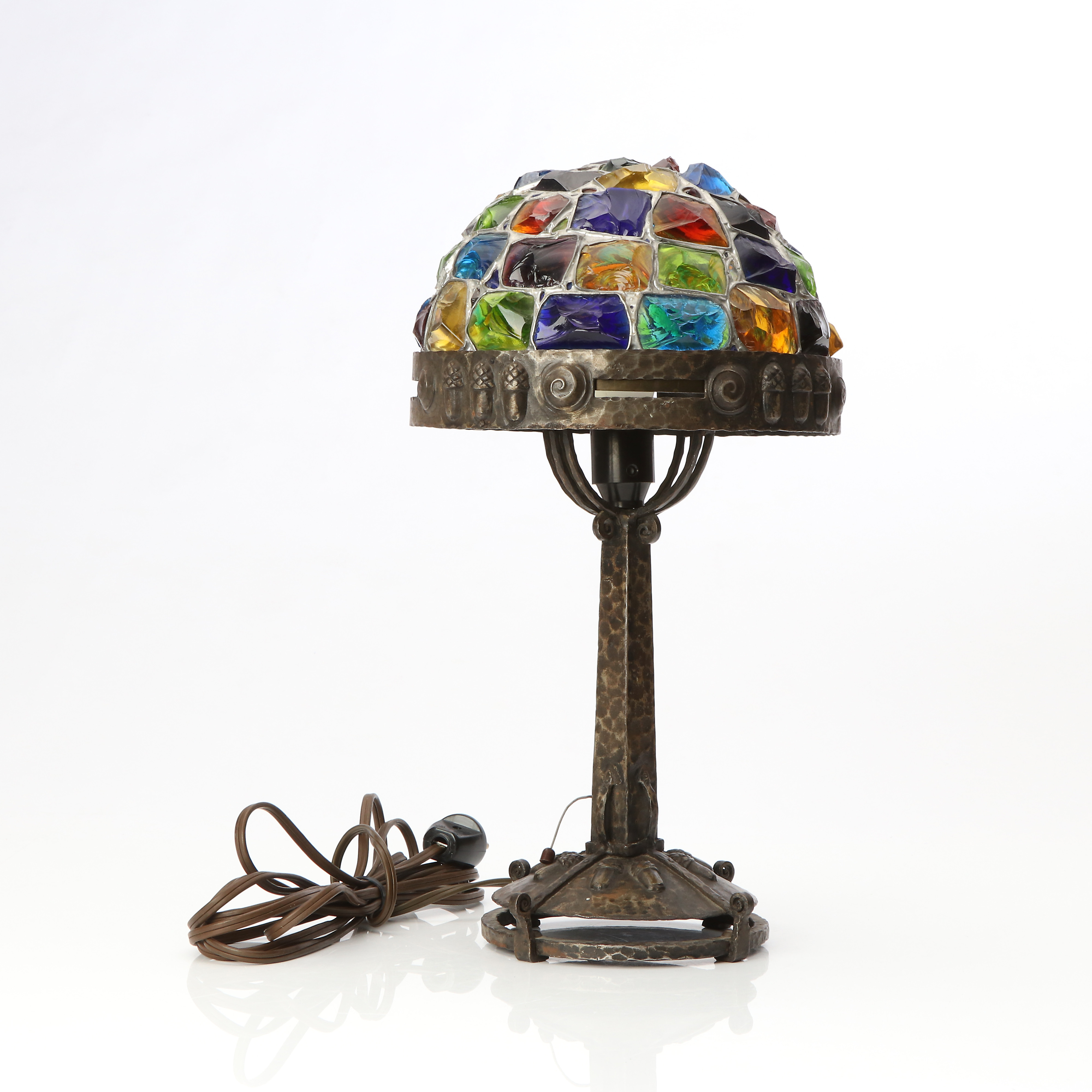 BÖHLMARKS, BORDSLAMPA. Hamrat smide med dekor av ekollon, skärm av infattade glasprismor i olika färger. Jugend, tidigt 1900-tal.