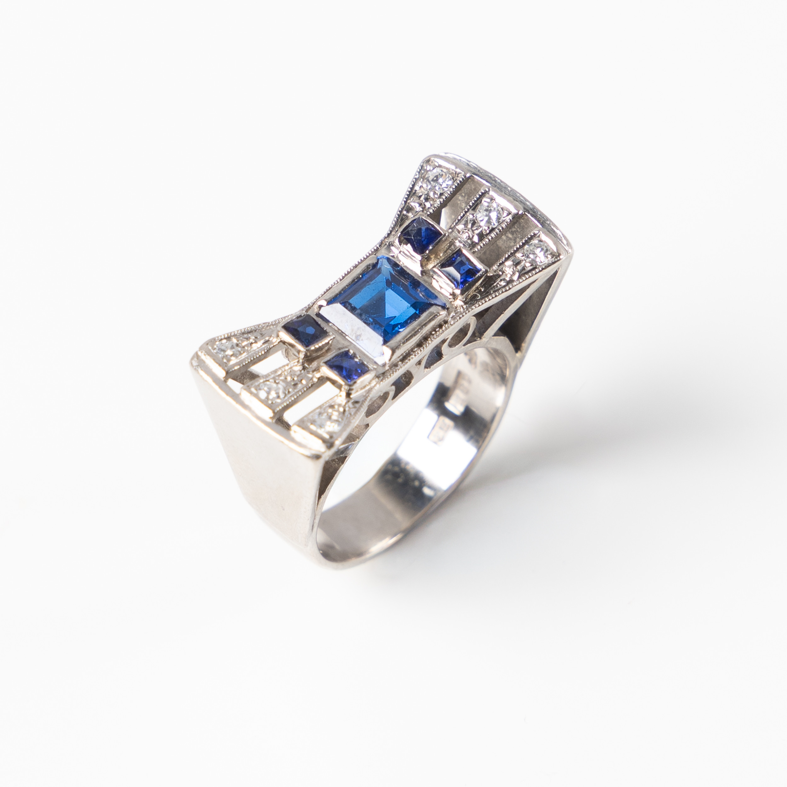 RING, 18K guld vitguld, med troligtvis syntetisk safir samt 4 st mindre safirer och åttkantslipade diamanter, Tesi, Göteborg, 1955.