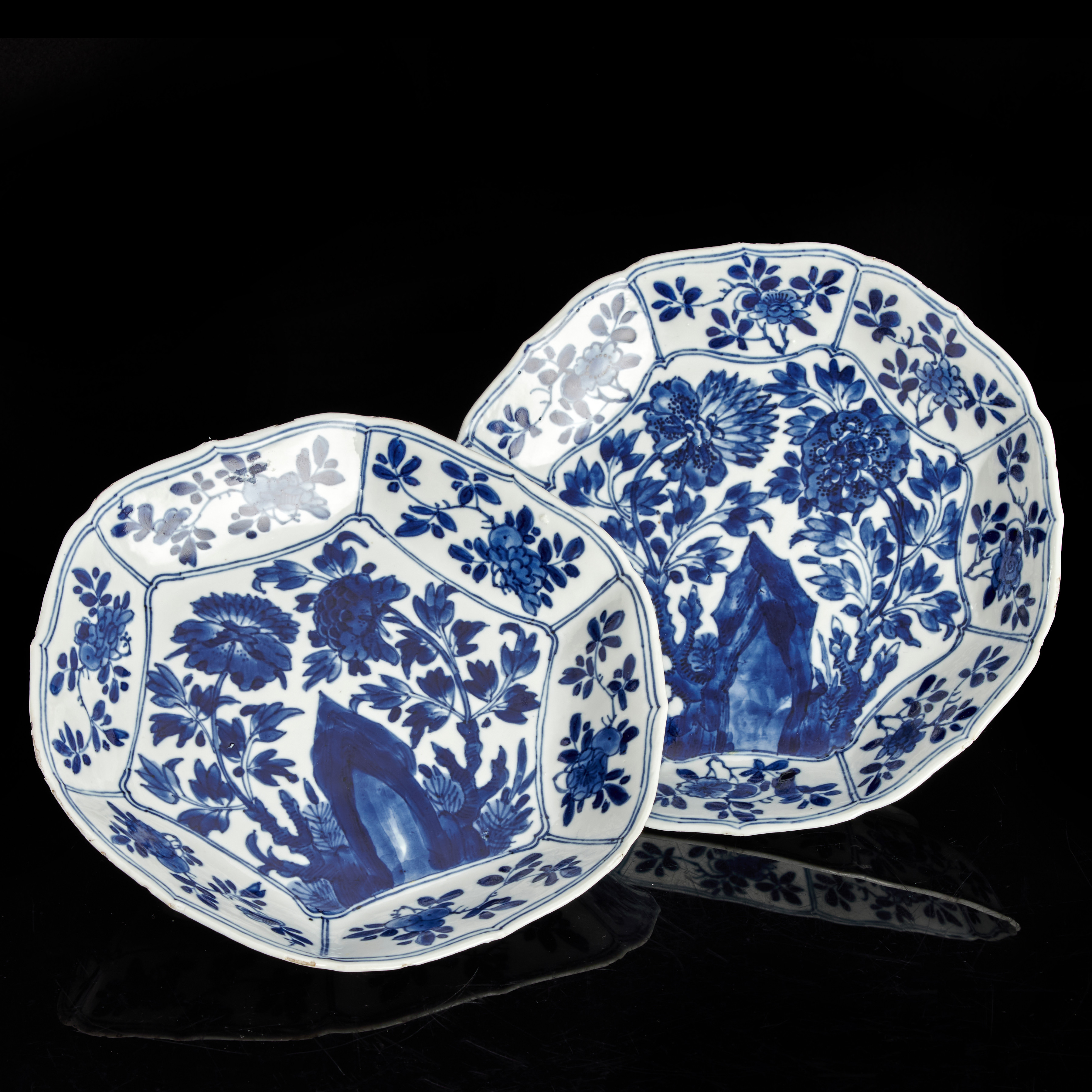 SKÅLFAT, ett par (snarlika), porslin, Kina, konturerad kant, dekor i underglasyrblått av blommande trädgård, Kangxi (1661-1722).