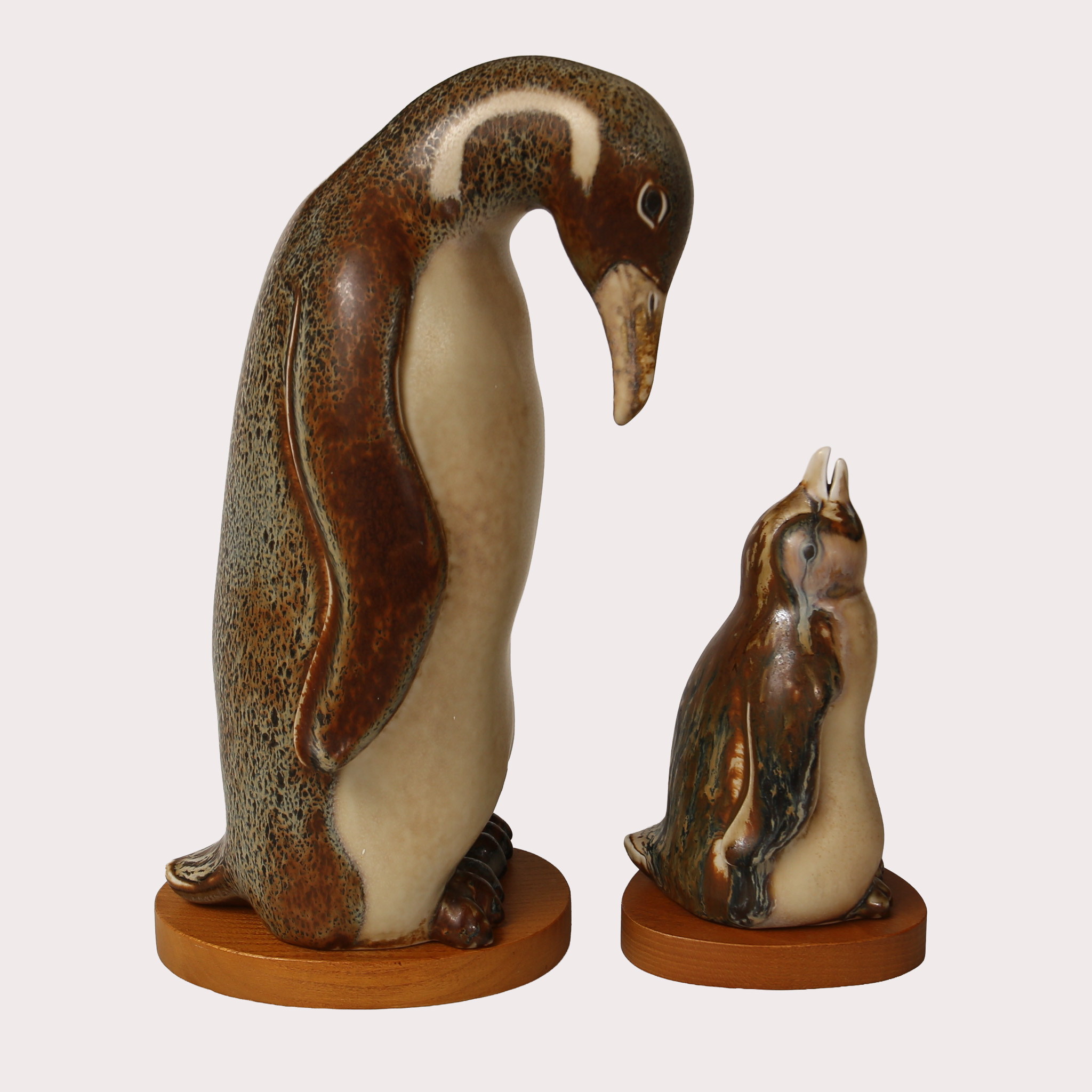 GUNNAR NYLUND. Figuriner i form av 2 pingviner på träplattor, stengods, Rörstrand.