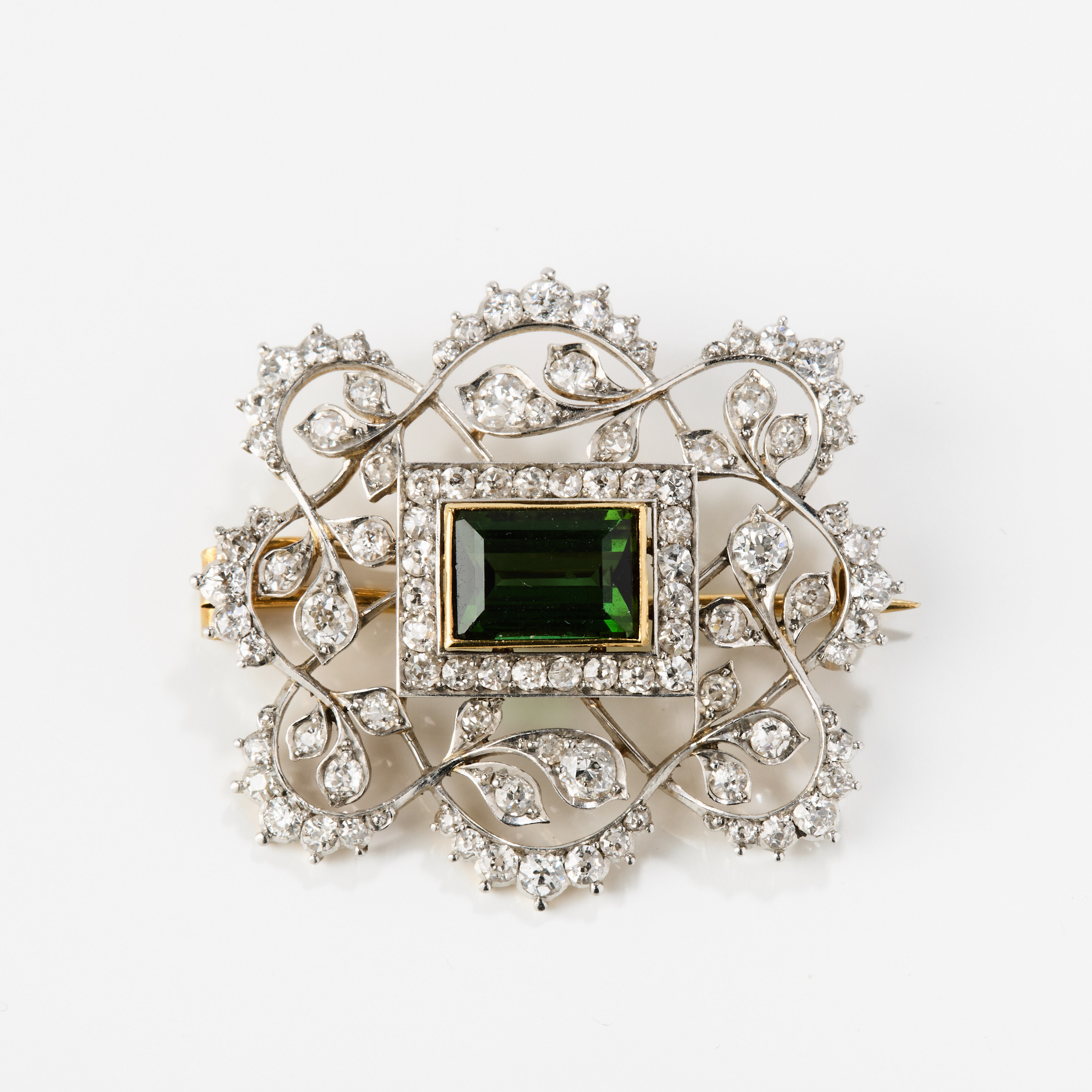 BROSCH, 18K guld/platina med en grön turmalin och diamanter, 1910/20-tal.