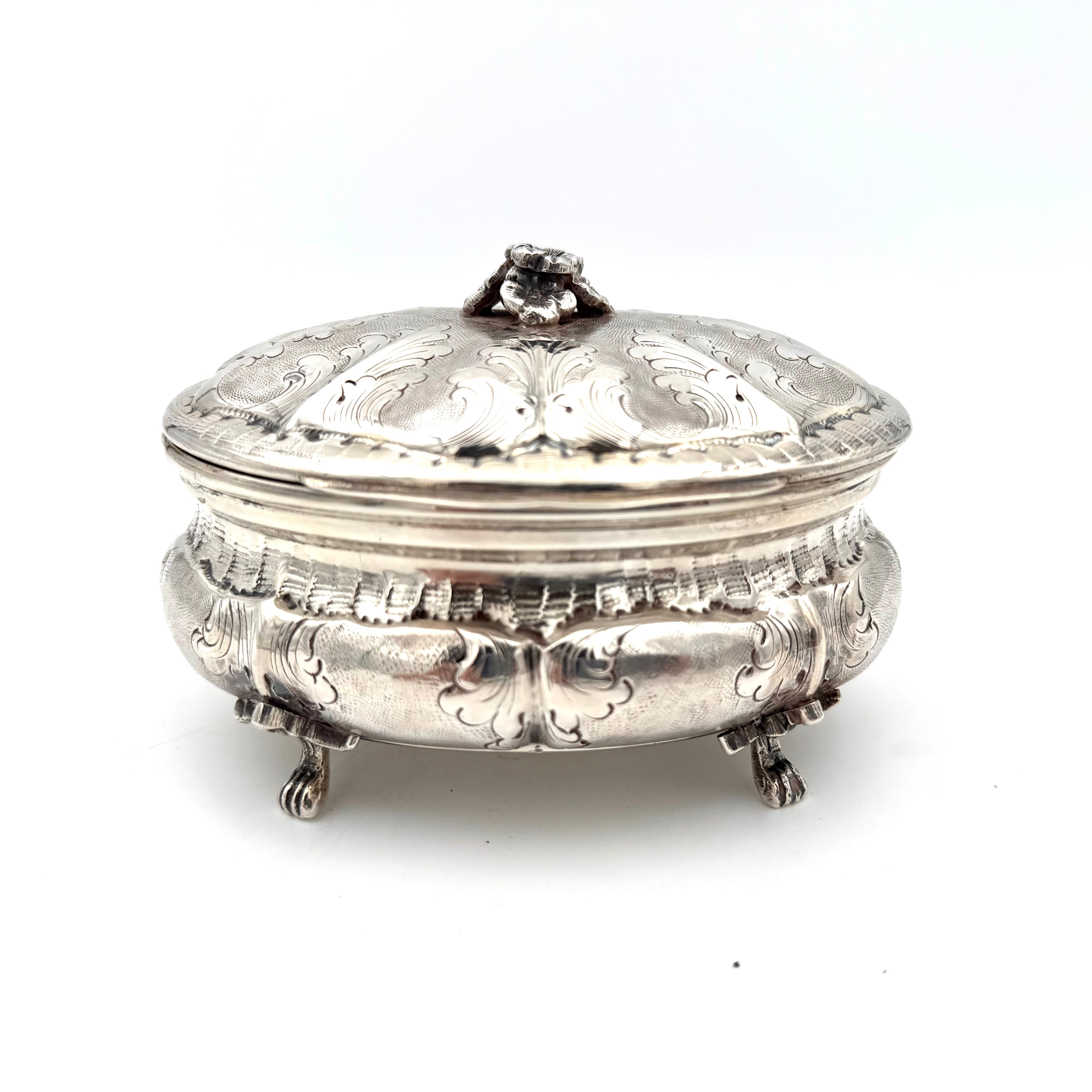 SOCKERSKRIN, rokokostil, silver/835, svenska importstämplar, bukig form på tassfötter, liv och lock med ciselerade raka knäckar, graverad och punsat dekor av bladornamentik, lockknopp i form av blomsterbukett.