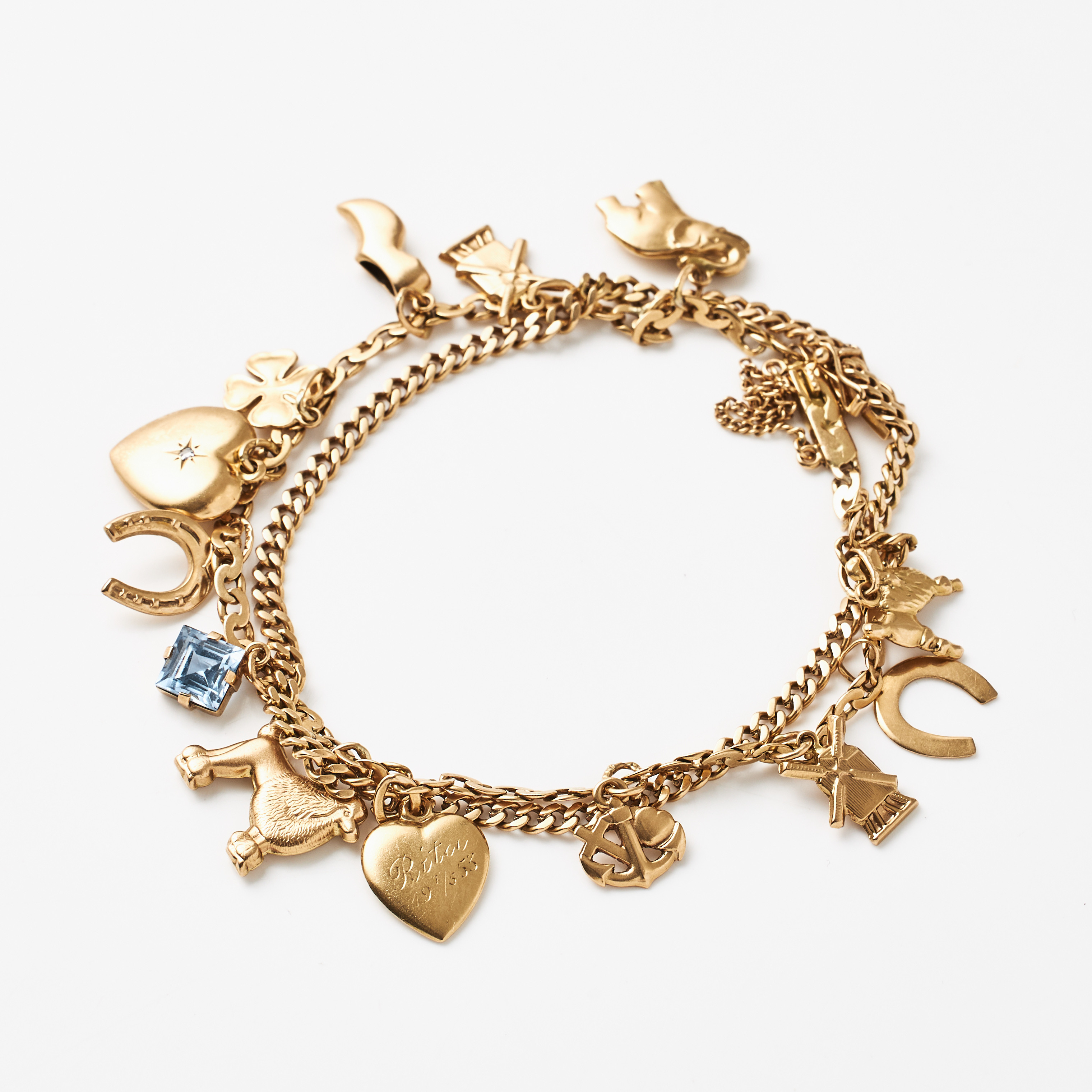 ARMBAND, 18 k guld, 2 ihopsatta olika manglade pansarlänkar, med berlocker bl a föreställande pudlar, elefant, hjärta, hästsko, en länk stämplad Gustaf Dahlgren & Co, Malmö 1944.