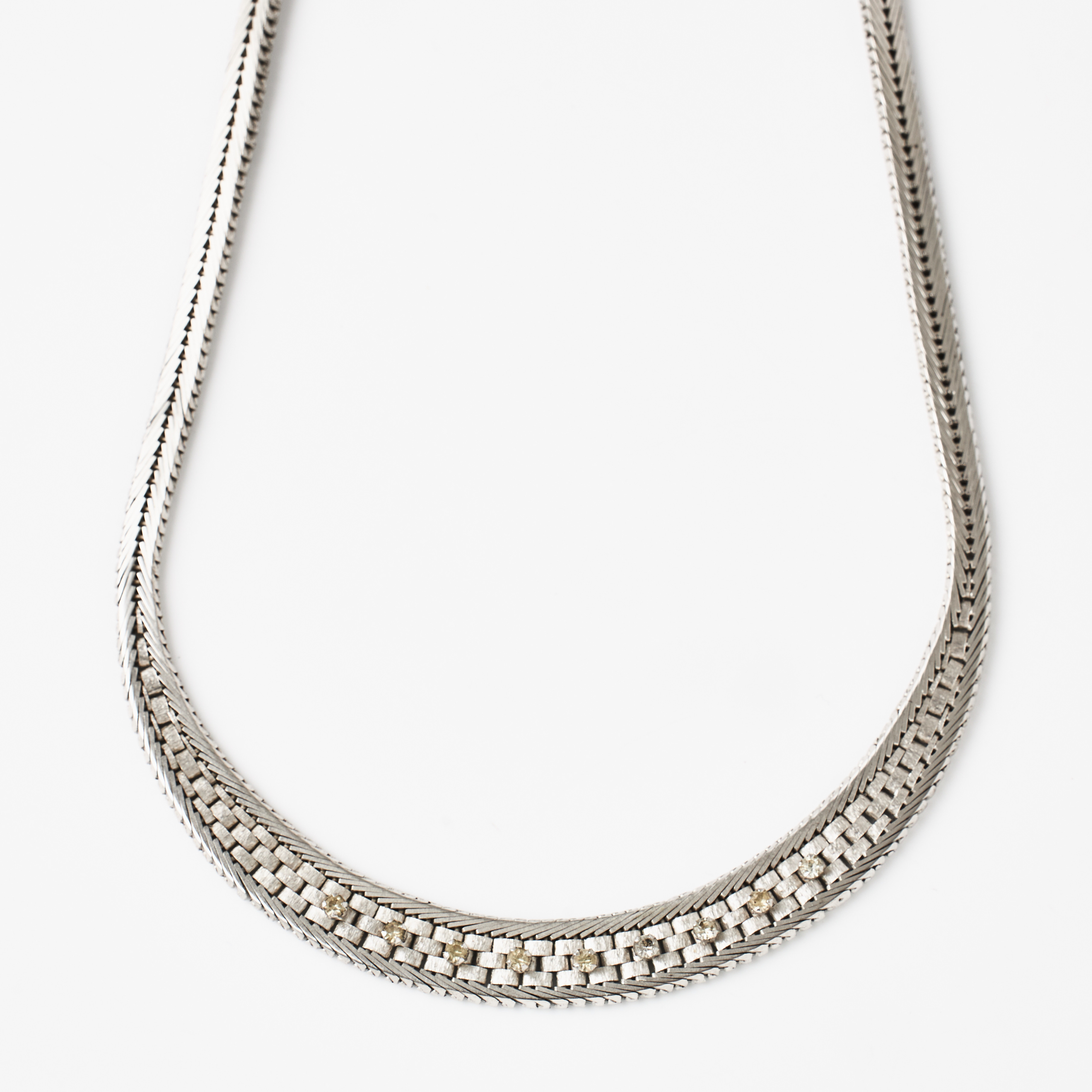 COLLIER, matterat och blankslipat silver, doserat, mittparti med dekor av fasettslipade vita stenar, svenska kontrollstämplar.