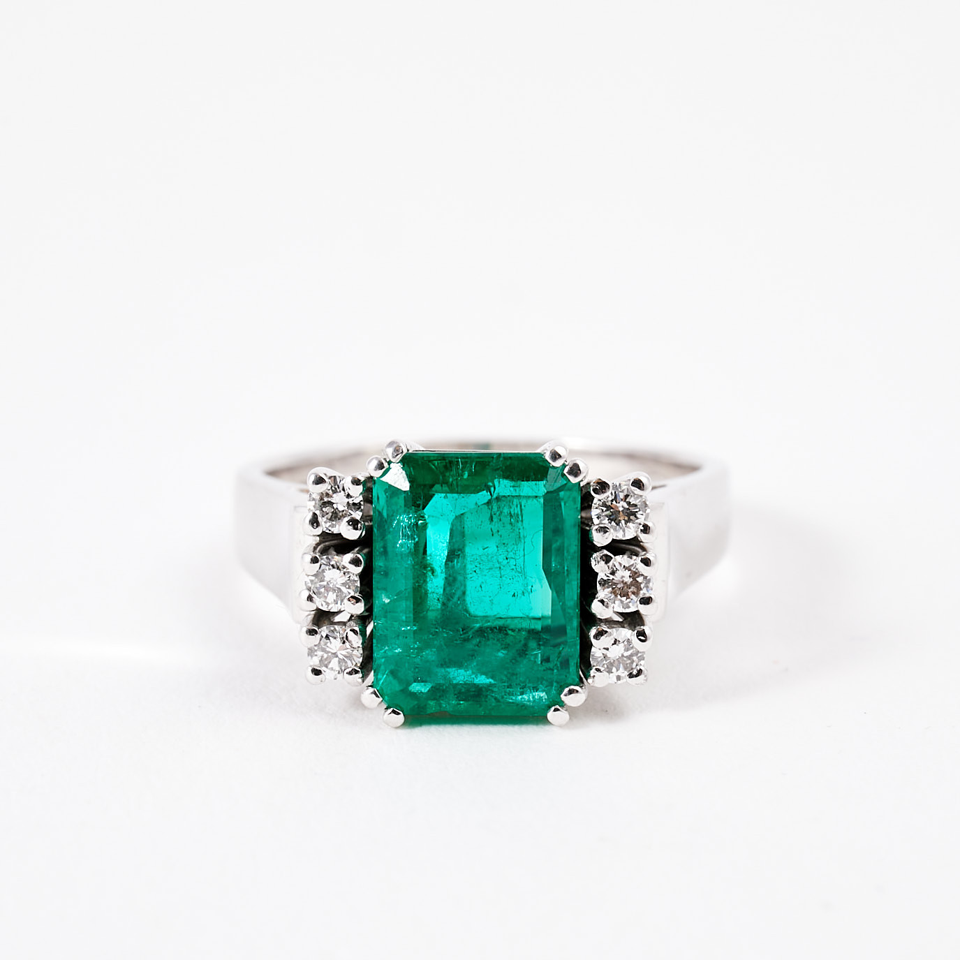 RING, 18 k vitguld, 1 smaragdslipad smaragd, 1,75-2,00 ct, flankerad av 6 briljantslipade diamanter, totalt 0,24 ct, Stockholm 1986.