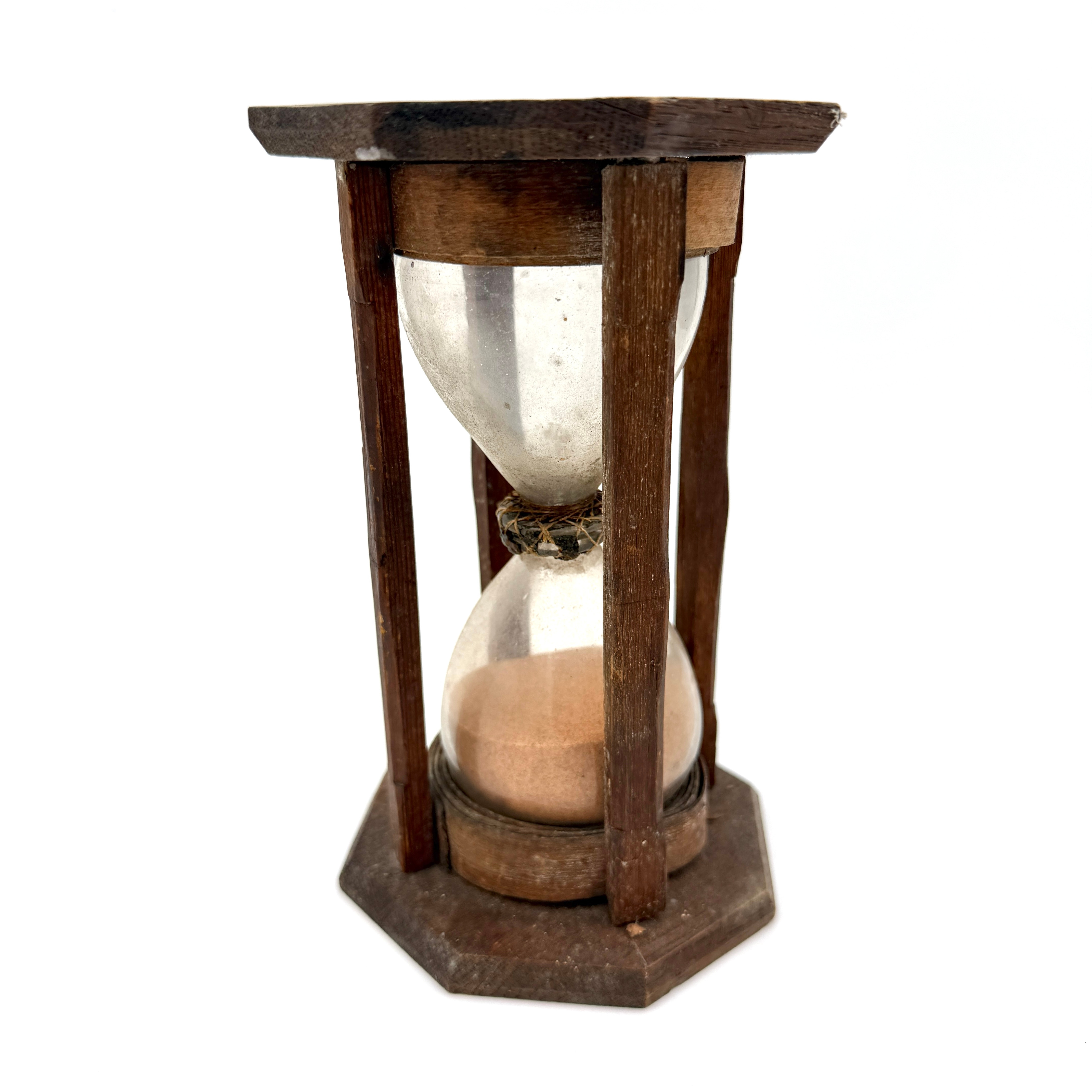 TIMGLAS, s ka vaktglas, 1800-tal, 2-delat glas, respektive med puntelmärke, klar glasmassa, ställning av trä med dekorativt fasade detaljer, oktagonal topp- och bottenplatta i ek, glasen sammanfogade med flätverk av tråd och lack.