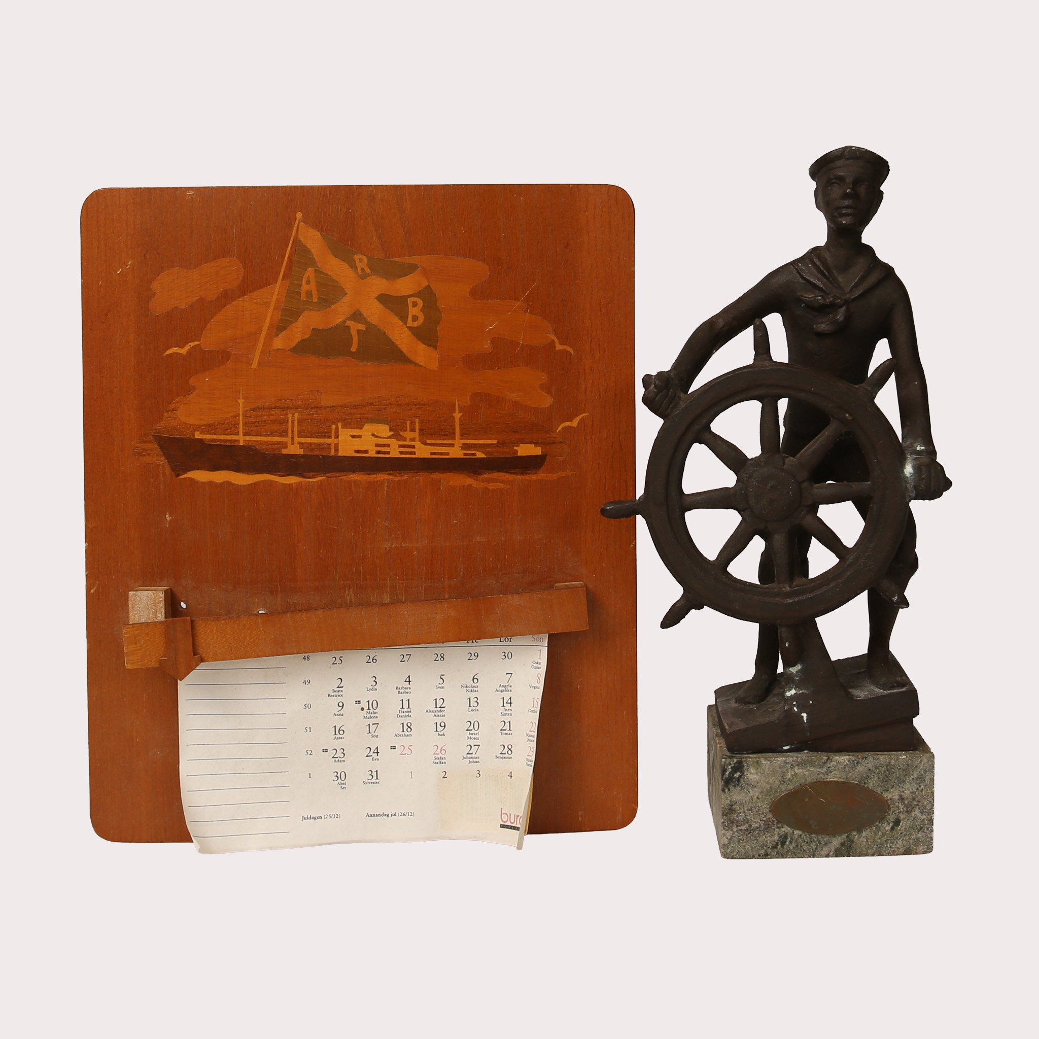 SKULPTUR, brons, "Ung sjöman vid ratten", ALMANACKSHÅLLARE, trä med intarsia. Omkring 1900-talets mitt.